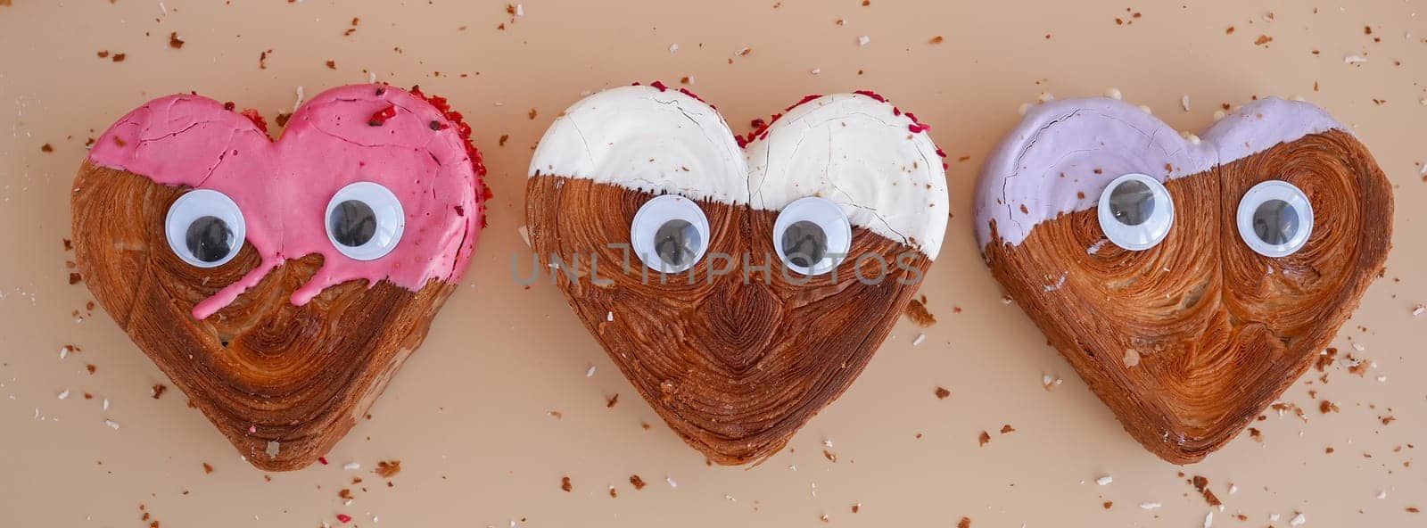 Funny food game face with crazy eyes April fool day joke Delightful and vibrant heartshaped pastry croissant treat, beautifully topped with colorful frosting galore. Copy space. Food experimentation viral dessert creative baking trend