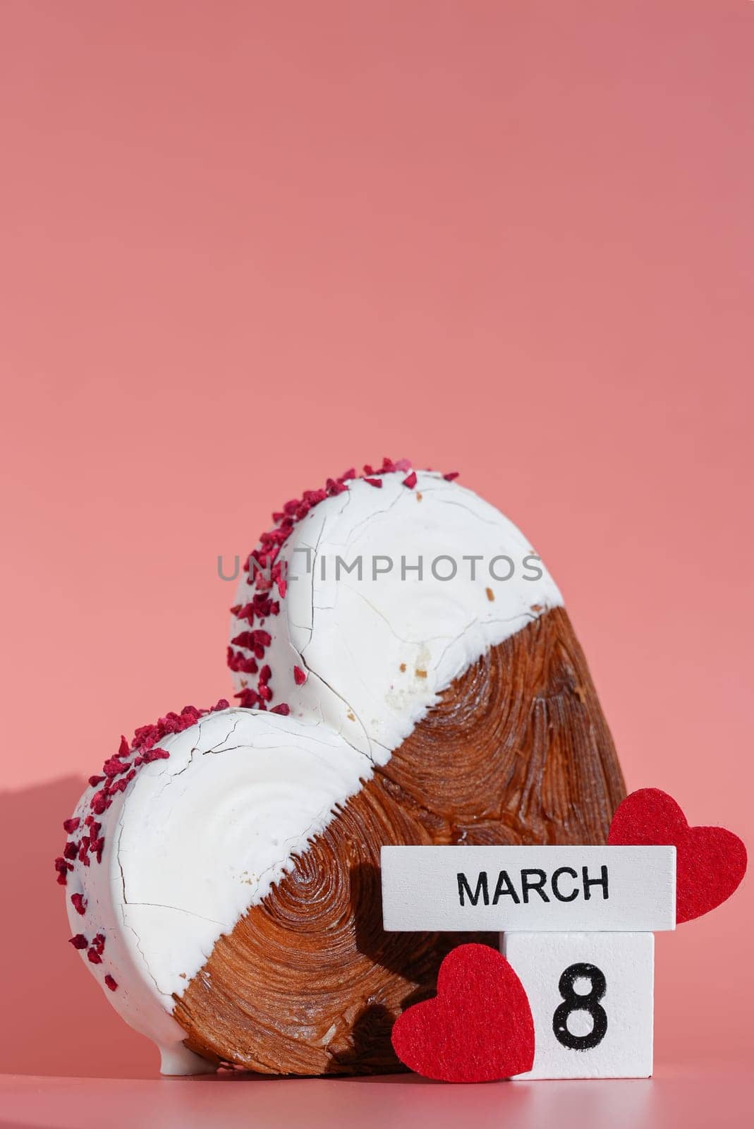 8 March international women's day Heart shaped white chocolate croissant on pink background with copy space. Puff pastry new trendy sweet dessert bakery. Creamy dough experiment