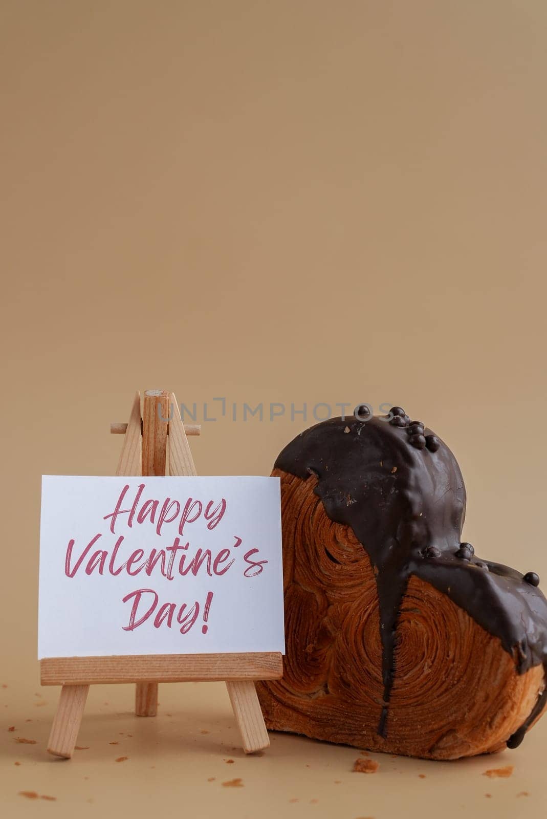 Happy Valentine's Day saying caption on greeting card Delightful and vibrant heartshaped pastry croissant treat, beautifully topped with colorful frosting galore. Copy space. Food experimentation viral dessert creative baking trend