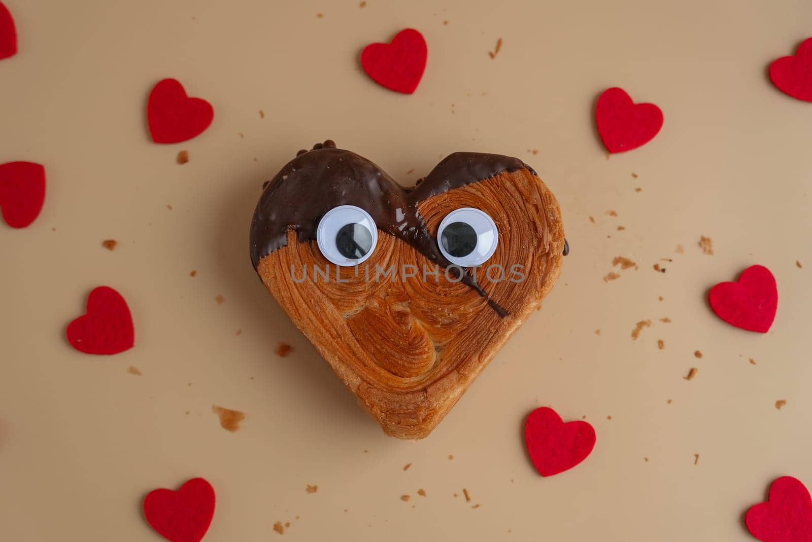 Funny food game face with crazy eyes April fool day joke Delightful and vibrant heartshaped pastry croissant treat, beautifully topped with colorful frosting galore. Copy space. Food experimentation viral dessert creative baking trend