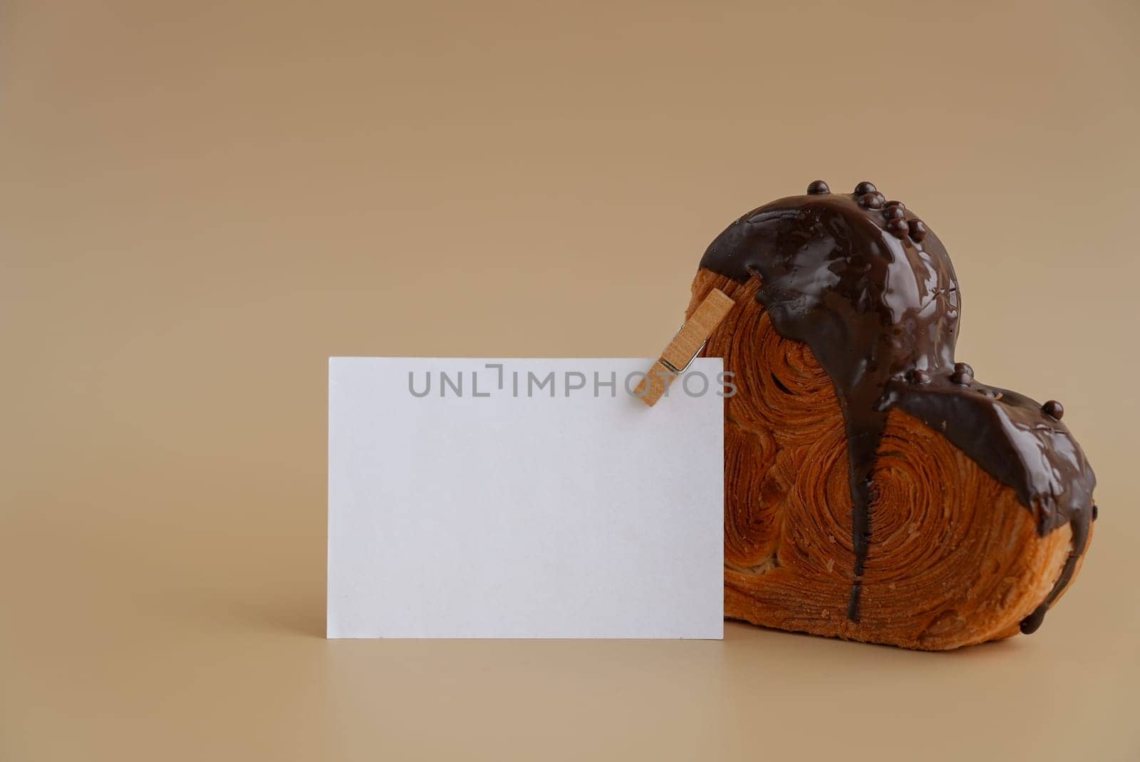 Empty paper note template sample mock up blank for wishes greeting holiday card Heartshaped pastry croissant treat topped with colorful frosting galore. Food experimentation viral dessert creative baking trend