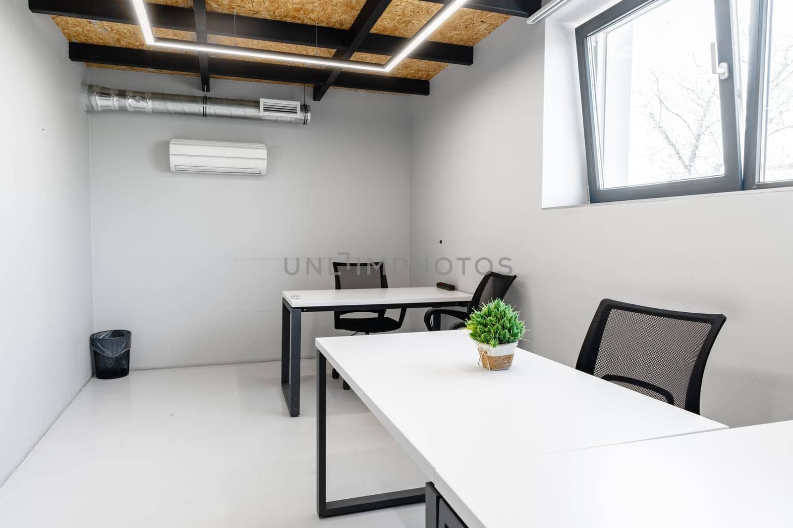 Bright office area featuring two desks and ergonomic chairs. The space has minimalist decor and effective lighting, perfect for productivity in a professional environment.
