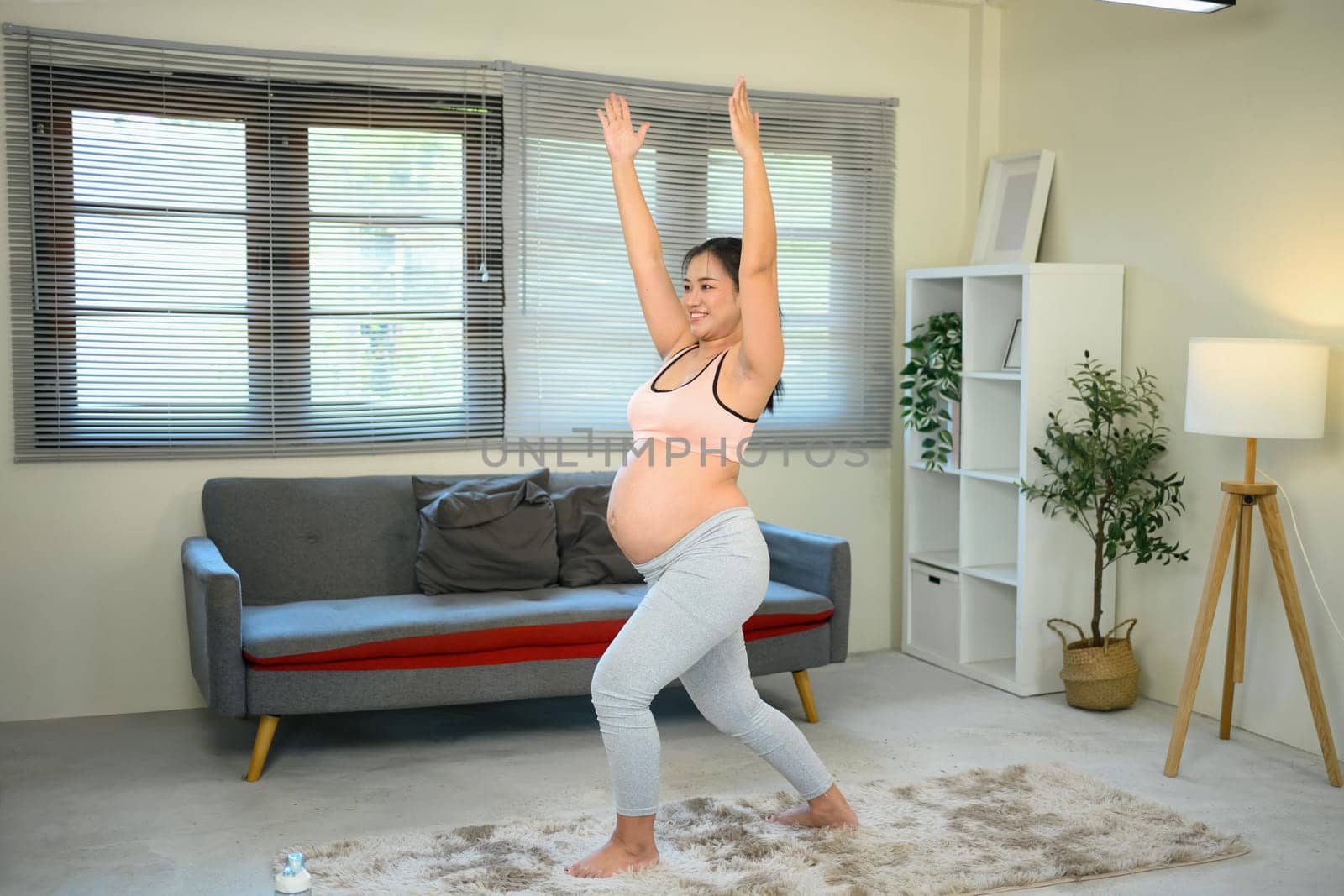 Pregnant woman practices yoga at home in her wellness routine..
