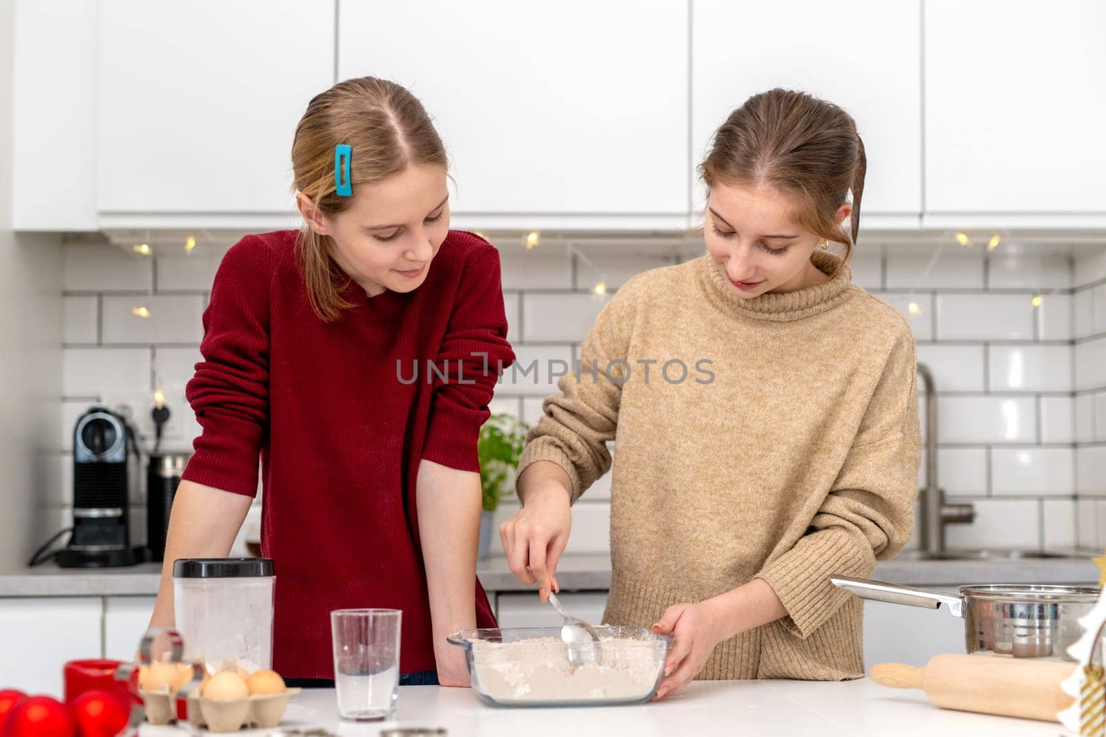 Happy Sisters Making Dough At Home In The Kitchen