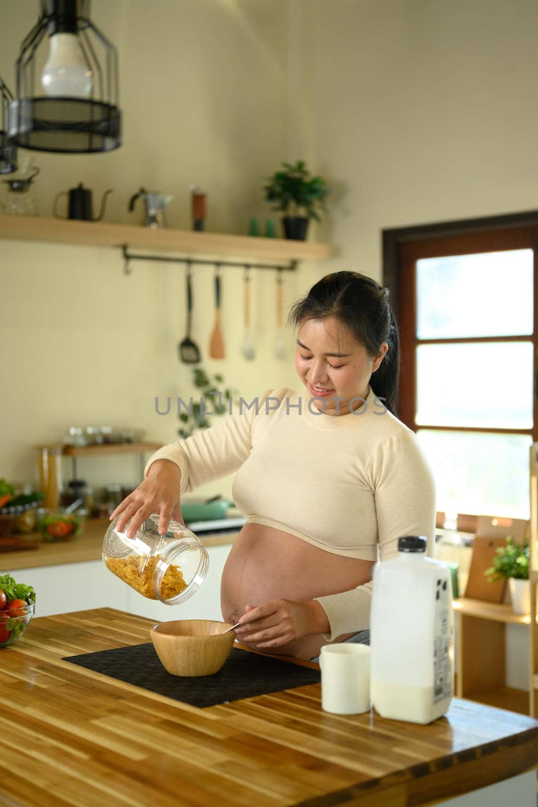 Pregnant woman pouring cereal for a healthy breakfast.