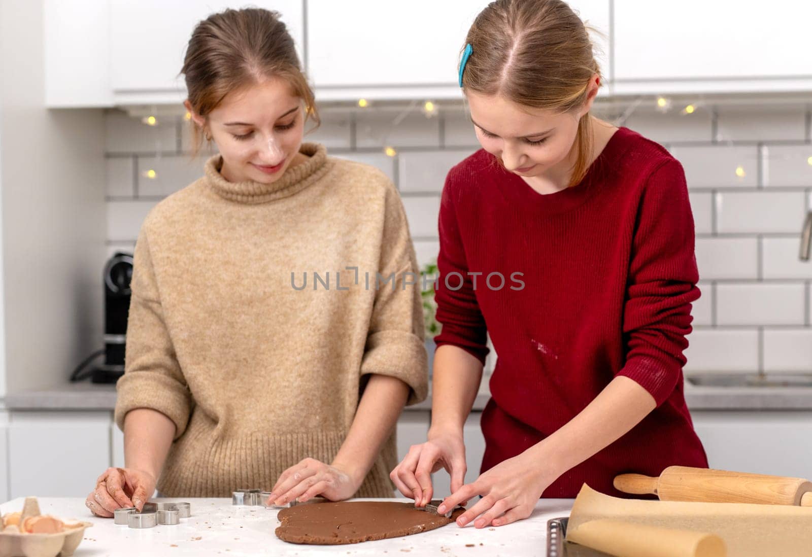 Teen Girls Making Gingerbread Cookies At Home In The Kitchen