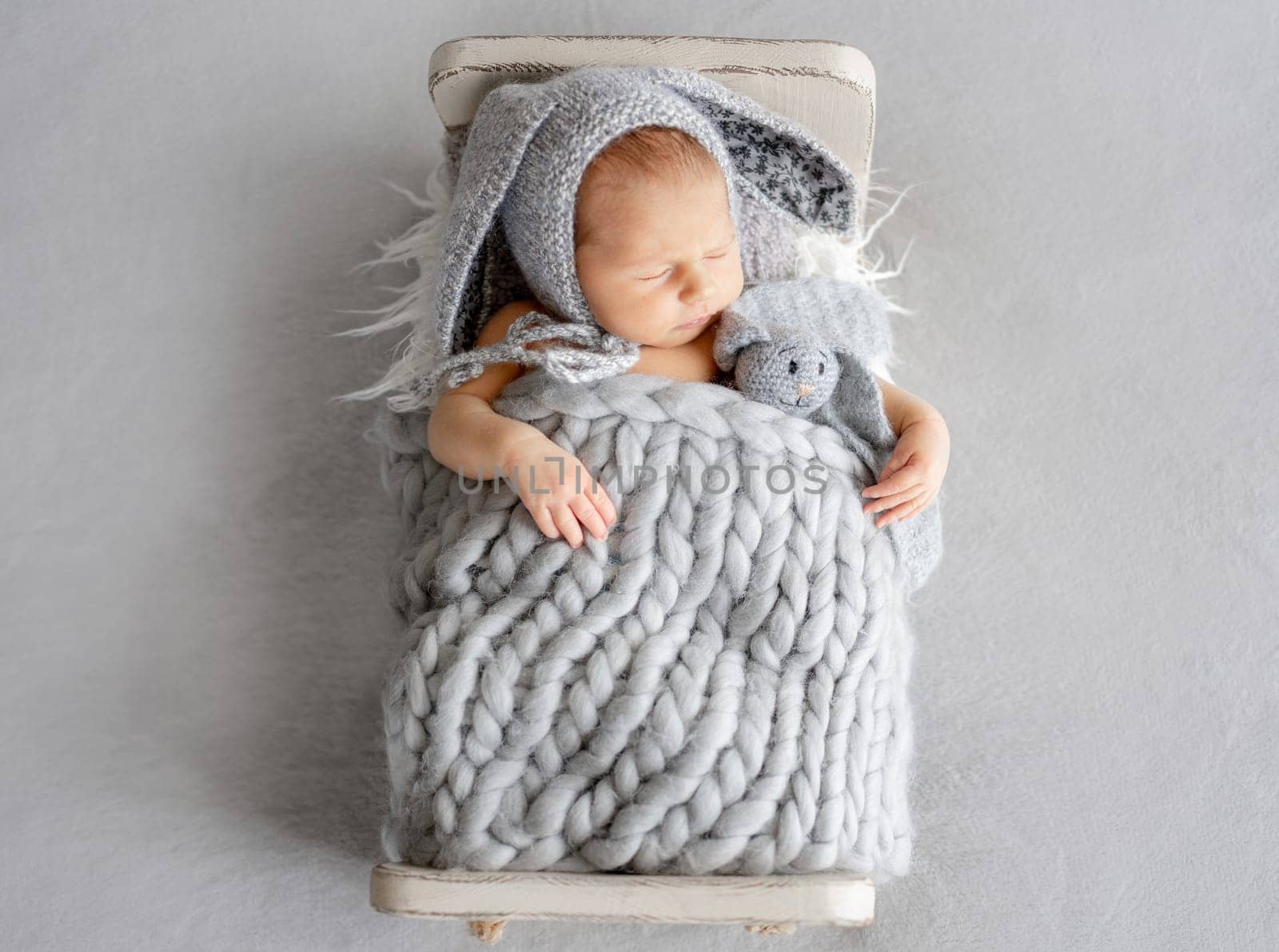 Newborn Baby Sleeping In A Bunny Hat In A Studio Photo