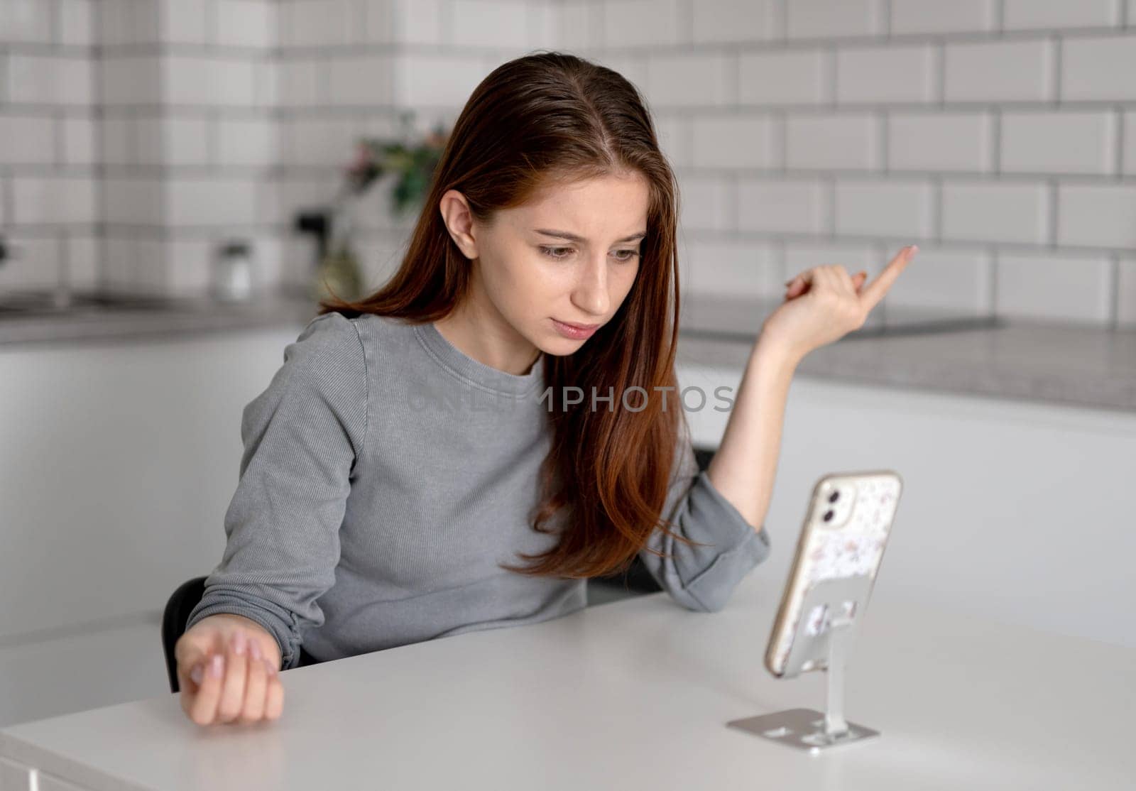 Unhappy Teen Girl Looking At Smartphone At Home