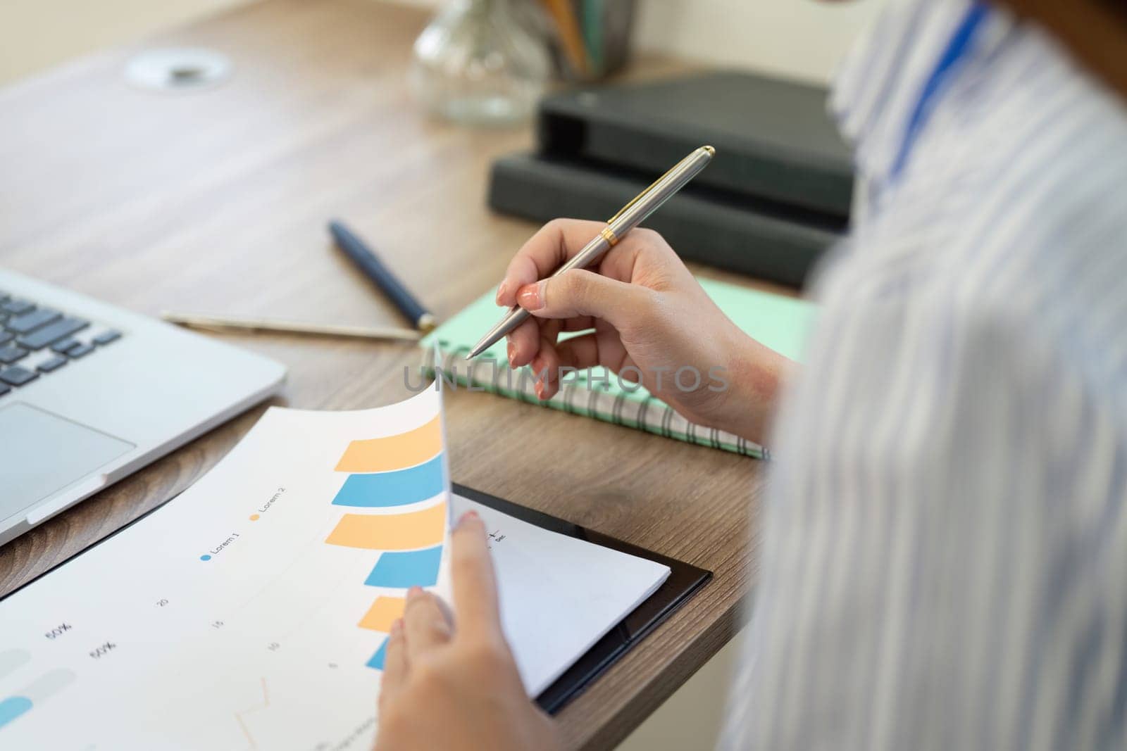 A professional analyzes data trends through charts, emphasizing analytical skills in a home office environment.