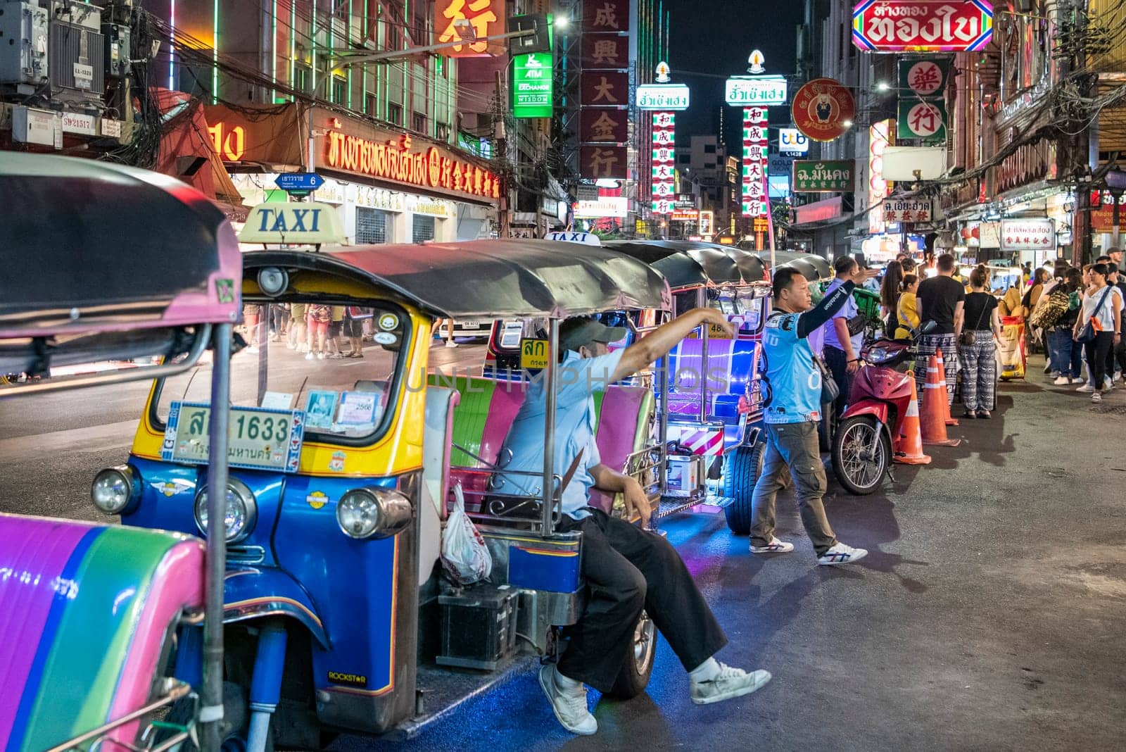 People and Tuk Tuk Taxi at Night Streetmarket on Yaowarat Road in Chinatown in City of Bangkok in Thailand.  Thailand, Bangkok, November, 4, 2024.