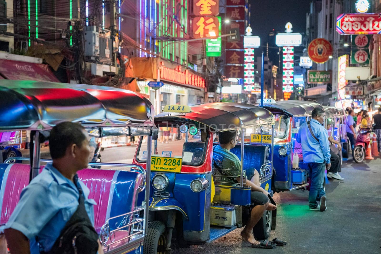 People and Tuk Tuk Taxi at Night Streetmarket on Yaowarat Road in Chinatown in City of Bangkok in Thailand.  Thailand, Bangkok, November, 4, 2024.