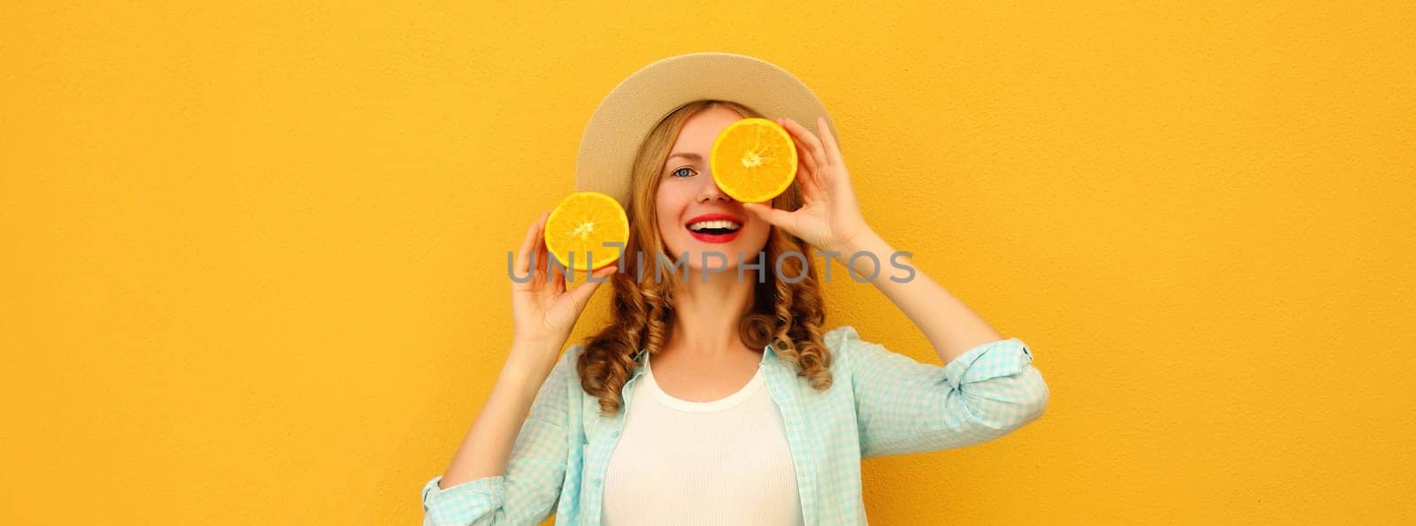 Summer portrait of happy joyful young woman with fresh slices of fresh orange fruits, cheerful girl smiles posing on bright yellow background