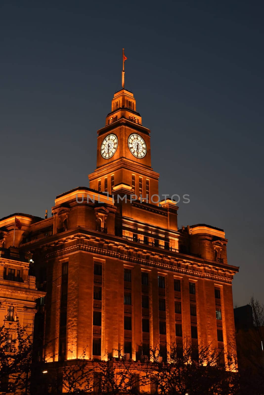 Shanghai, China - 1 April 2025: Historic Customs House building with illuminated clock tower at night on the Bund in central Shanghai