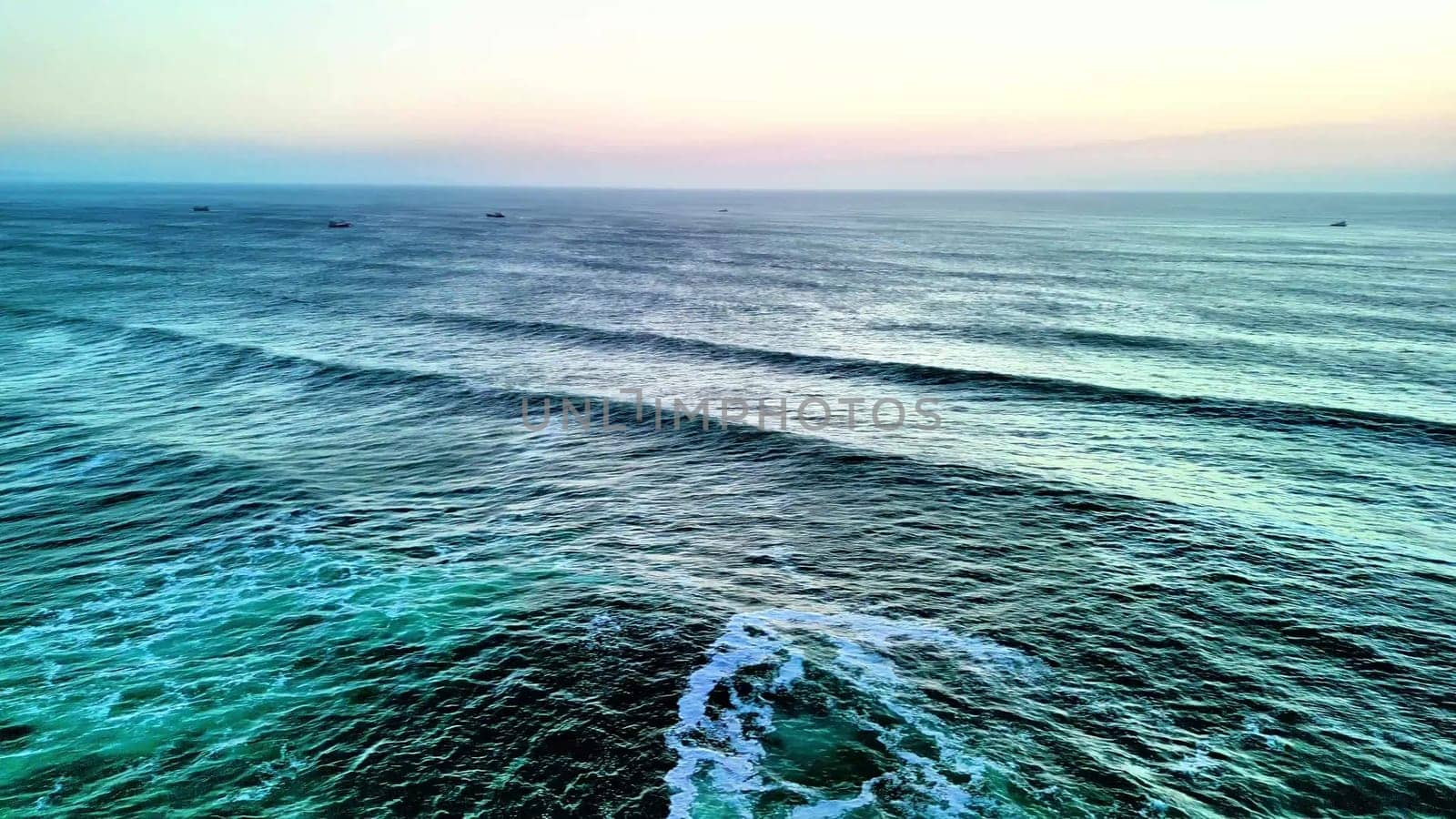 A breathtaking view of the ocean waves in calming colors during sunset, perfect for relaxation visuals.