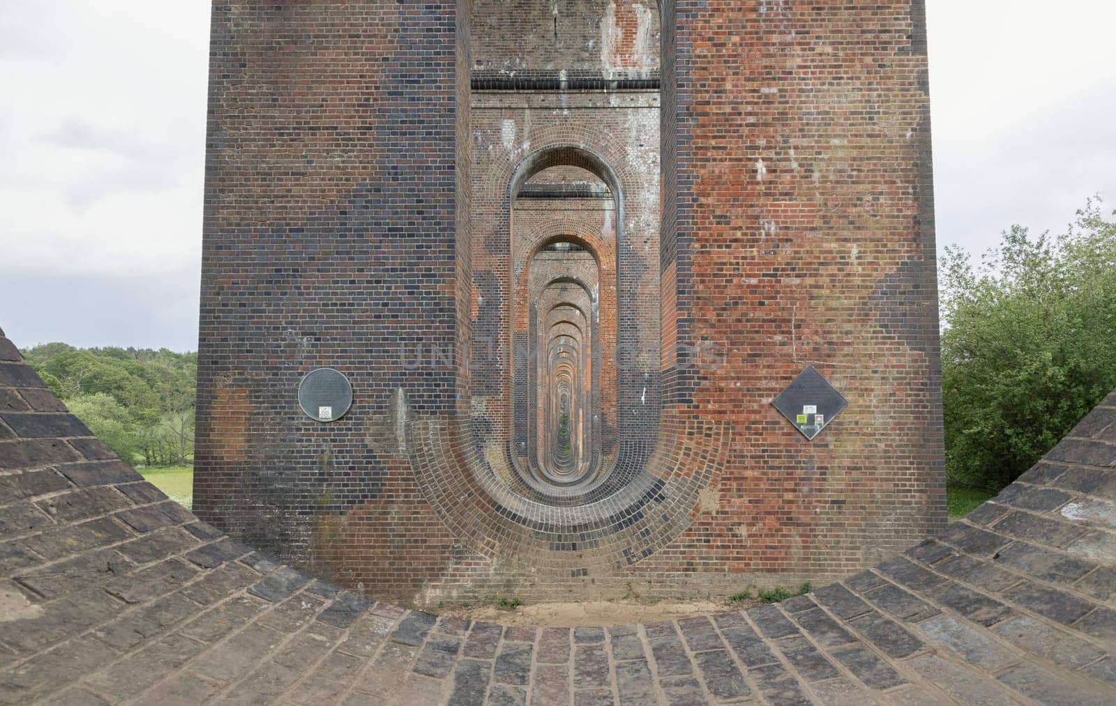 Sussex, UK - May 21, 2025 - Architectural splendour of Ouse Valley Viaduct or Balcombe Viaduct (Railway viaduct) has been described as “the most elegant viaduct in Britain” carries the Brighton Main Line over the River Ouse in Sussex. Semi-circular arches vaulting supporting traditional red brick piers topped with smooth limestone, use it as your Wallpaper, Poster and Copy space, Selective focus.