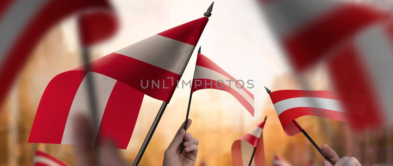 Austria flags in their hands on a blurred urban background. The photo illustration was created without the use of artificial intelligence, only using Photoshop.