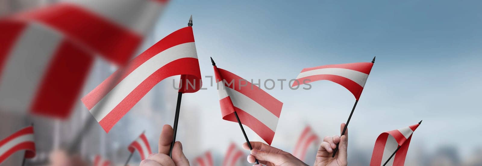 Austria flags in their hands on a blurred urban background. The photo illustration was created without the use of artificial intelligence, only using Photoshop.