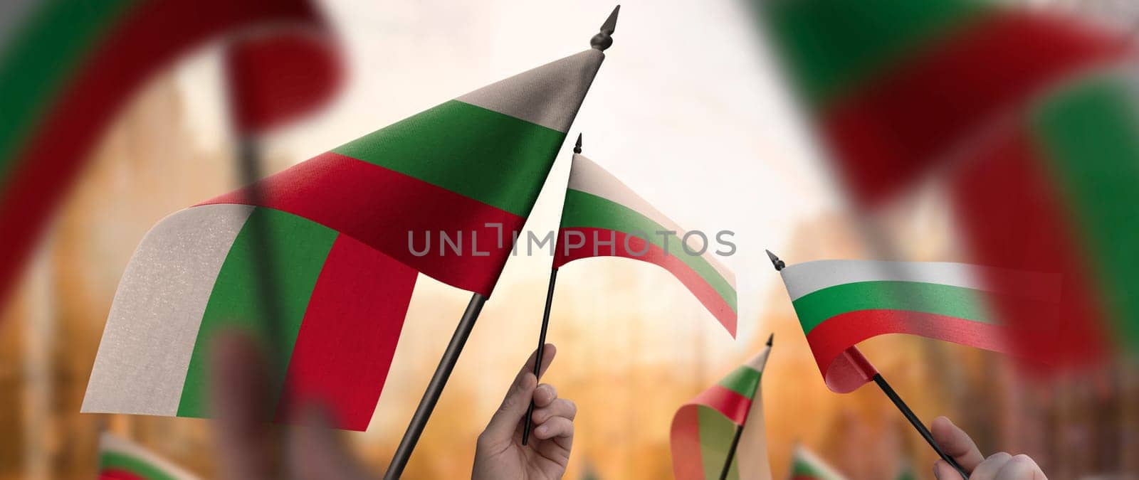 Bulgaria flags in their hands on a blurred urban background. The photo illustration was created without the use of artificial intelligence, only using Photoshop.