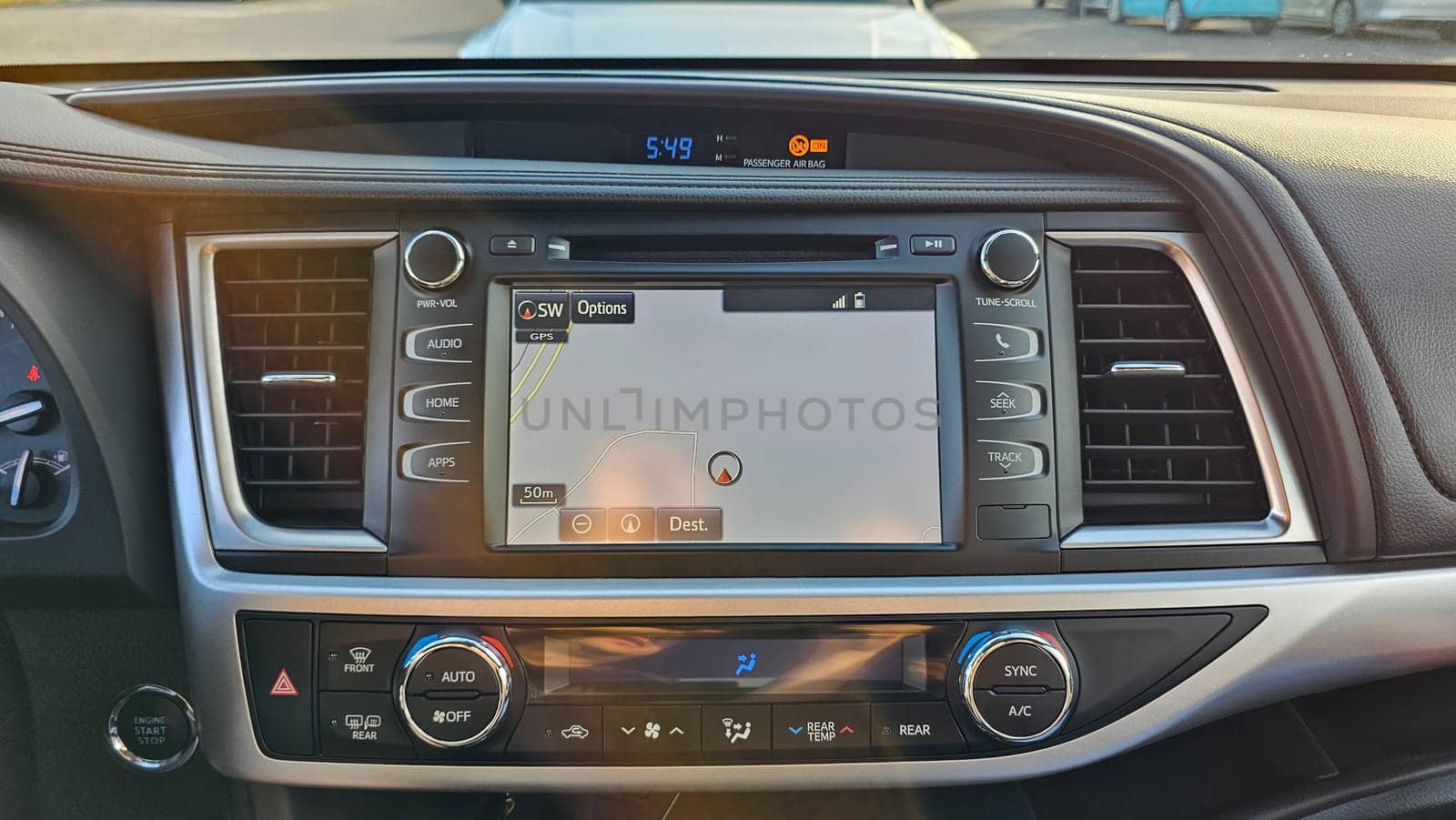 Daytime shot of a car s interior showcasing the dashboard with a navigation system display. Modern vehicle technology highlights convenience and connectivity for drivers.