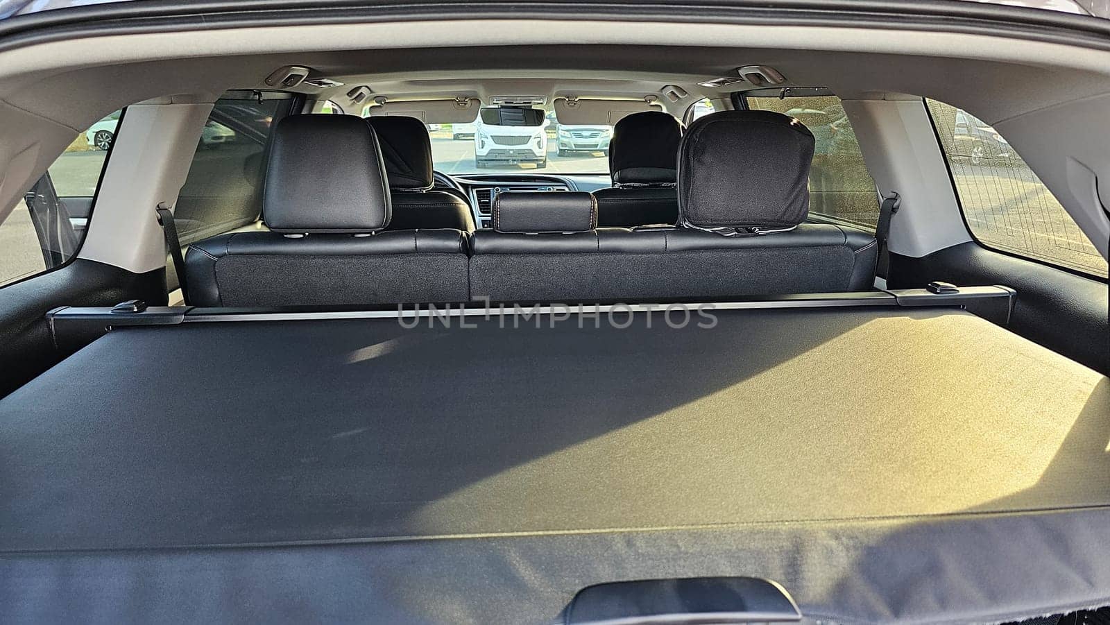 A view of a car s interior, highlighting the spacious trunk area with an extended cargo cover for storage. The rear seats provide comfortable seating for passengers during travel.
