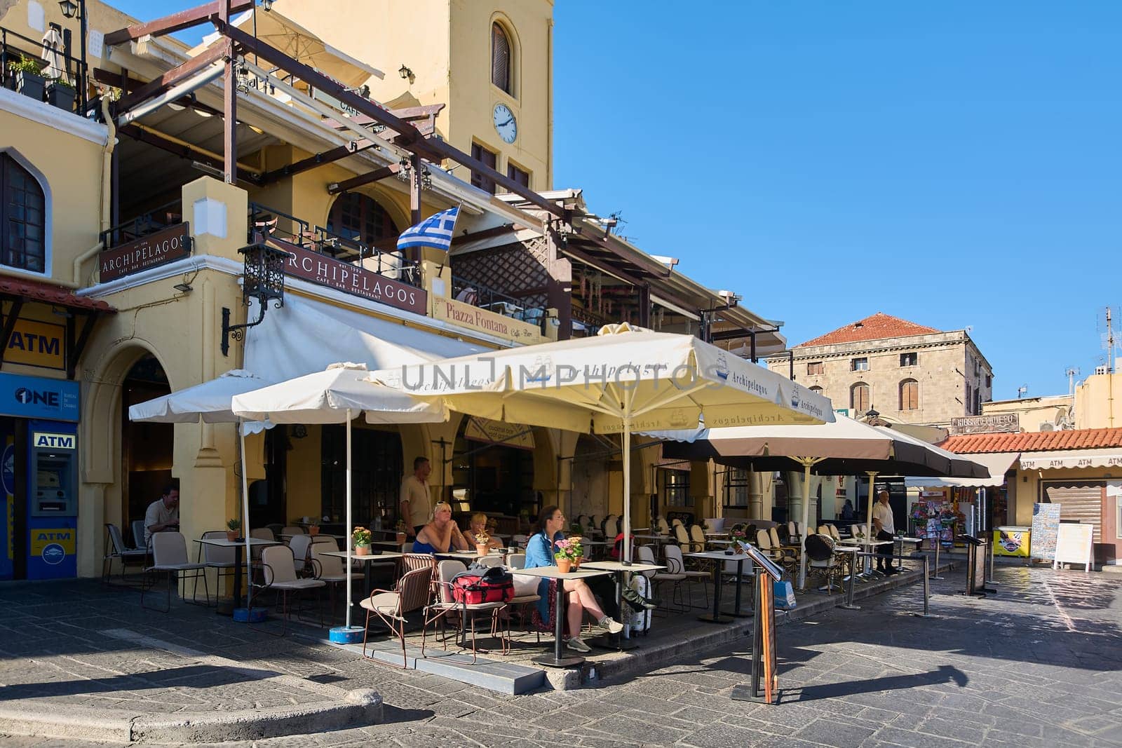 Rodas.Greece - may 22, 2025: This vibrant al fresco dining area in a historic Greek city, featuring charming tables and chairs, invites patrons to enjoy local cuisine and drinks amidst the picturesque old town ambiance.