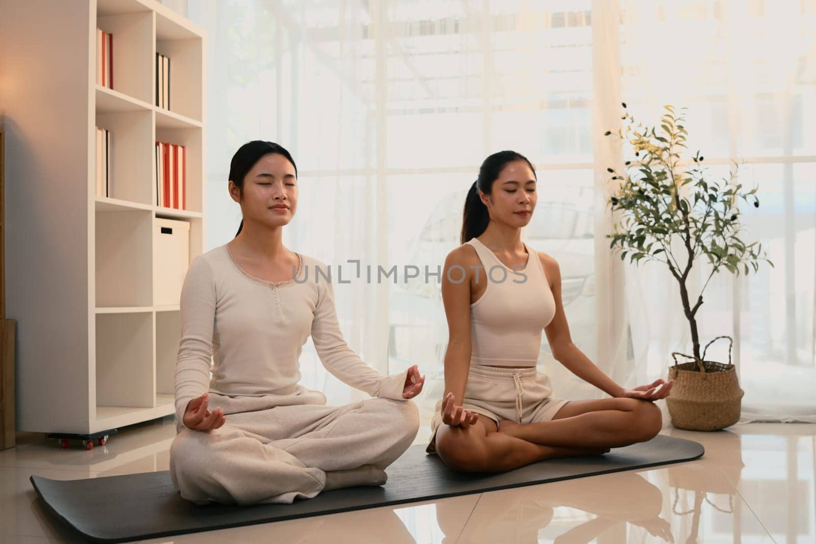 Peaceful mother and daughter practice mindfulness and meditation together.