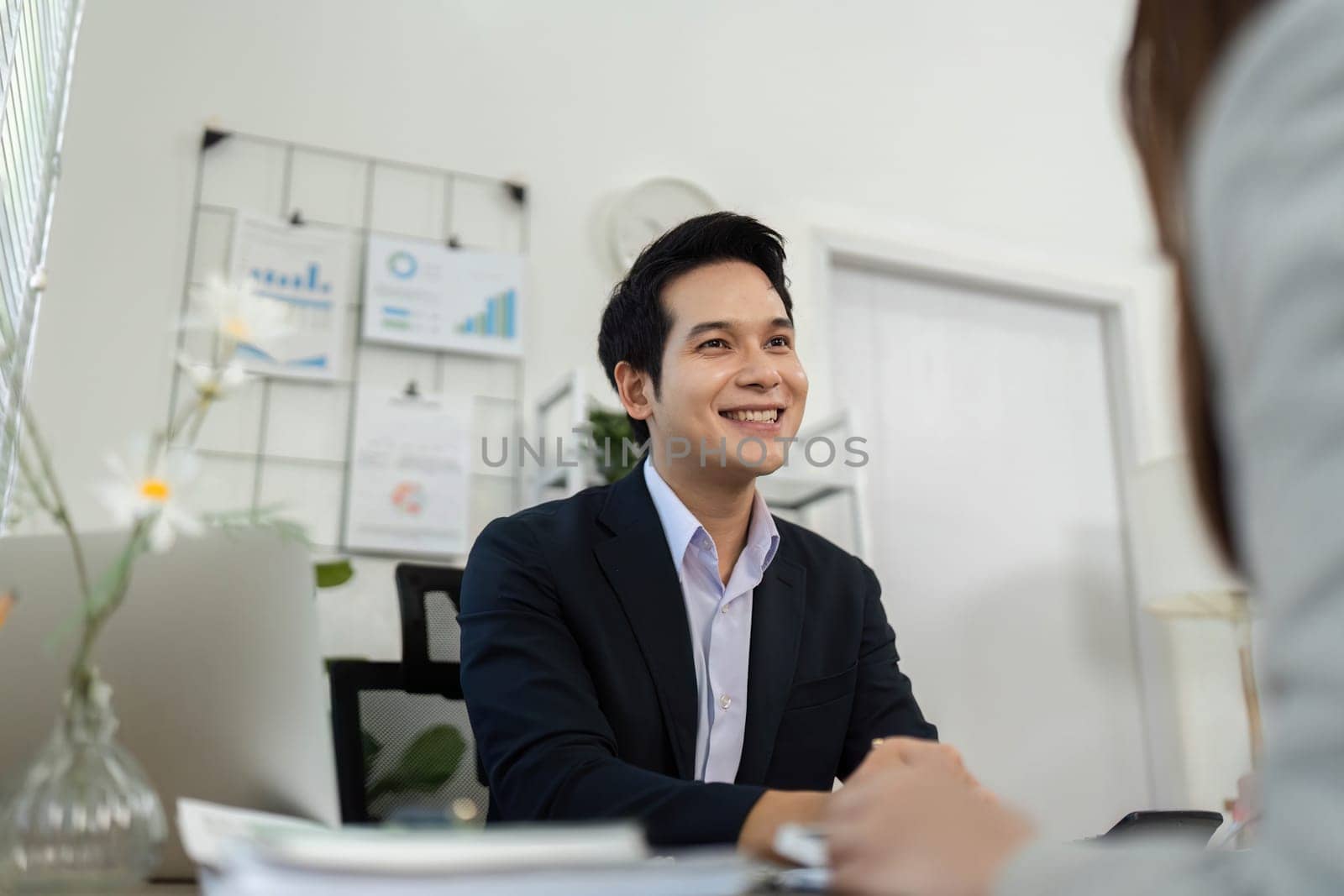 A business consultant smiling and engaging in conversation with a client, fostering a friendly and professional atmosphere.