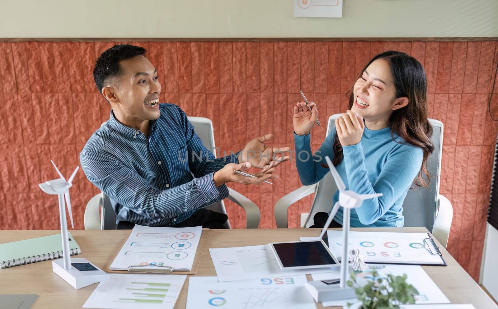 A man and woman discussing ESG initiatives in a modern office, showcasing collaboration and innovation in sustainability.
