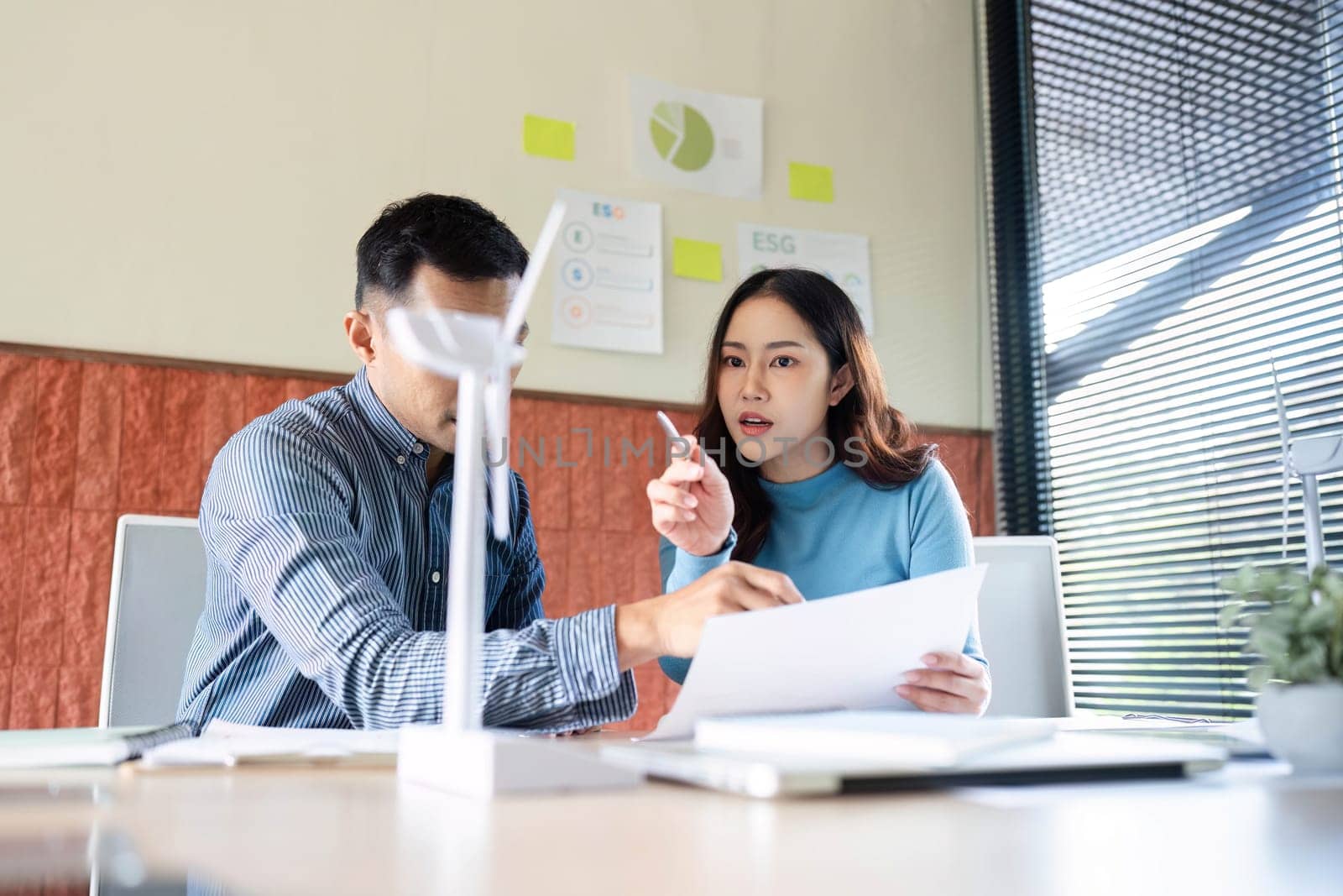 A focused discussion between colleagues about ESG initiatives. They analyze documents and share ideas in a collaborative workspace.
