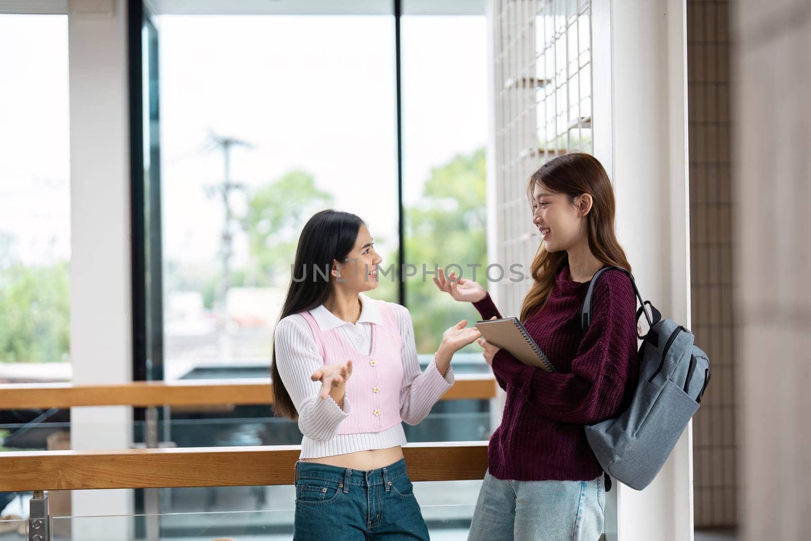 Two friends animatedly engage in conversation, capturing the excitement of collaborative discussions in an educational ambiance, emphasizing the warmth of friendship.