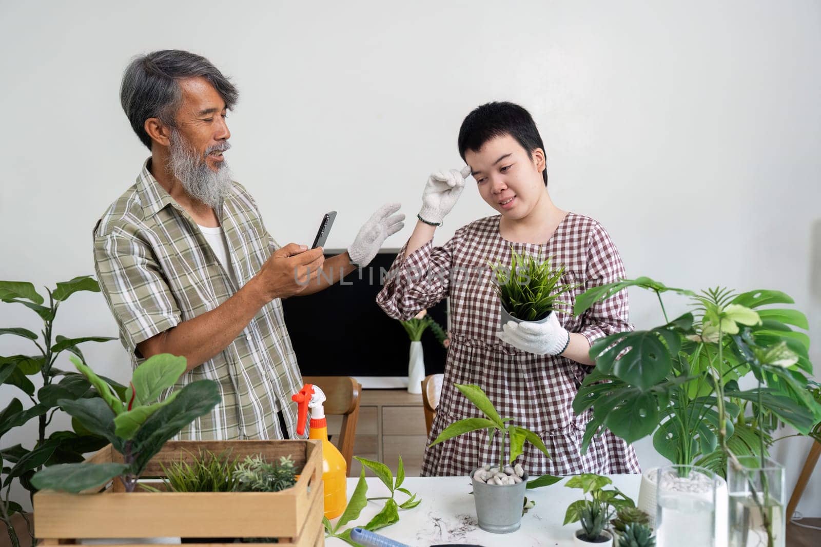 In a vibrant indoor garden, a young individual learns the art of potting plants under the watchful eye of an experienced gardener, emphasizing sustainable practices.