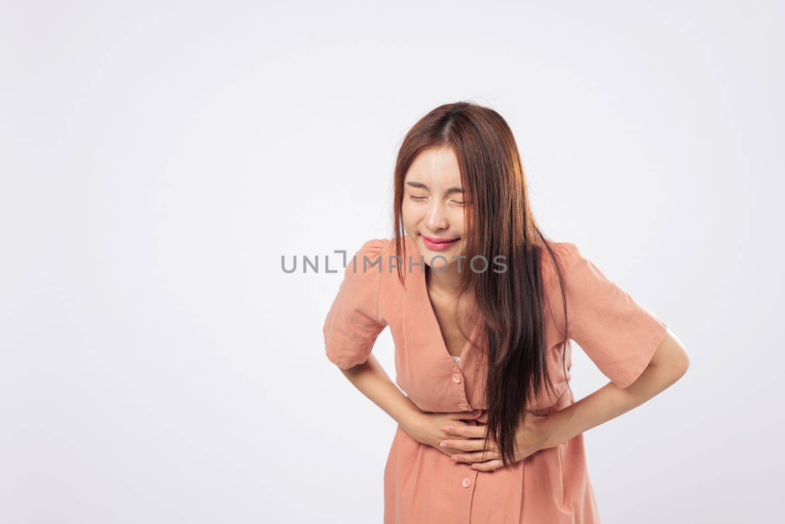 Stomach discomfort and stomach ache portrayed by a woman showing signs of period pain and internal cramp in a medical health concept isolated on studio white background
