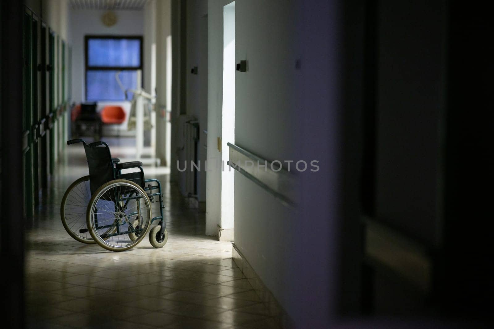 Unattended wheelchair positioned in a bright hospital corridor. Concept of accessibility and patient transport.