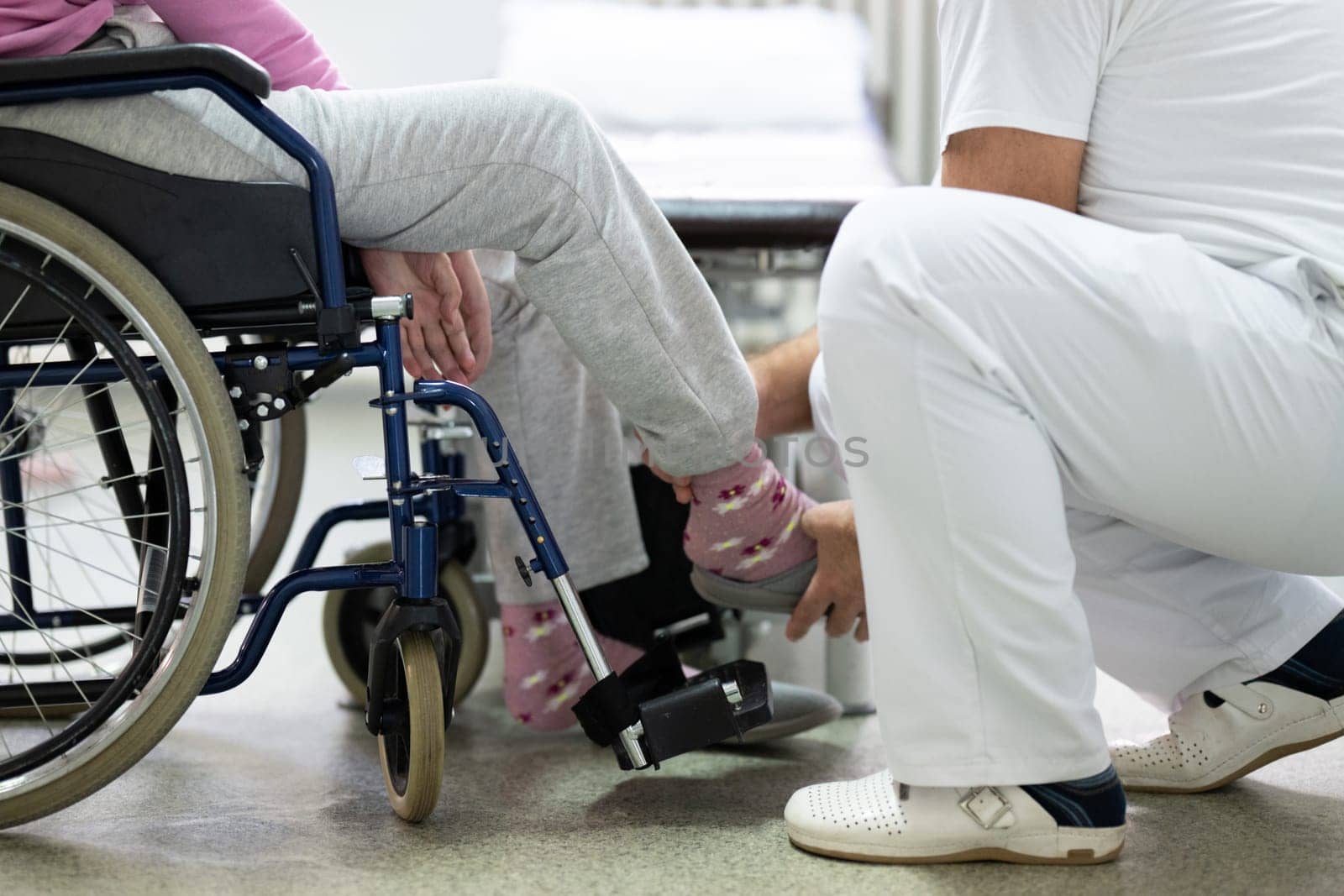 Senior woman doing physical exercises with the help of a smiling therapist. Concept of elderly rehabilitation and movement recovery.