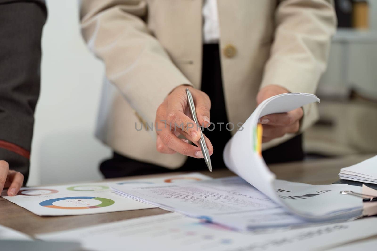 Two business professionals engage in a collaborative discussion over project documents, showcasing teamwork and communication in a modern office.
