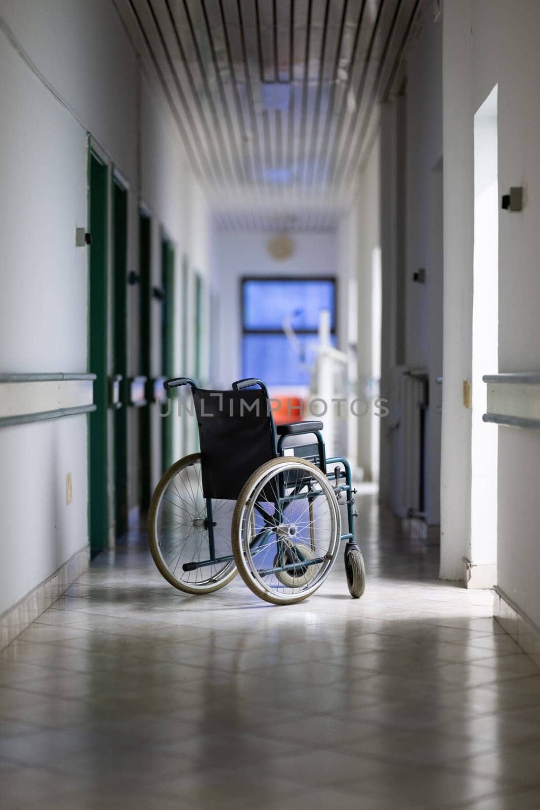 Unattended wheelchair positioned in a bright hospital corridor. Concept of accessibility and patient transport.