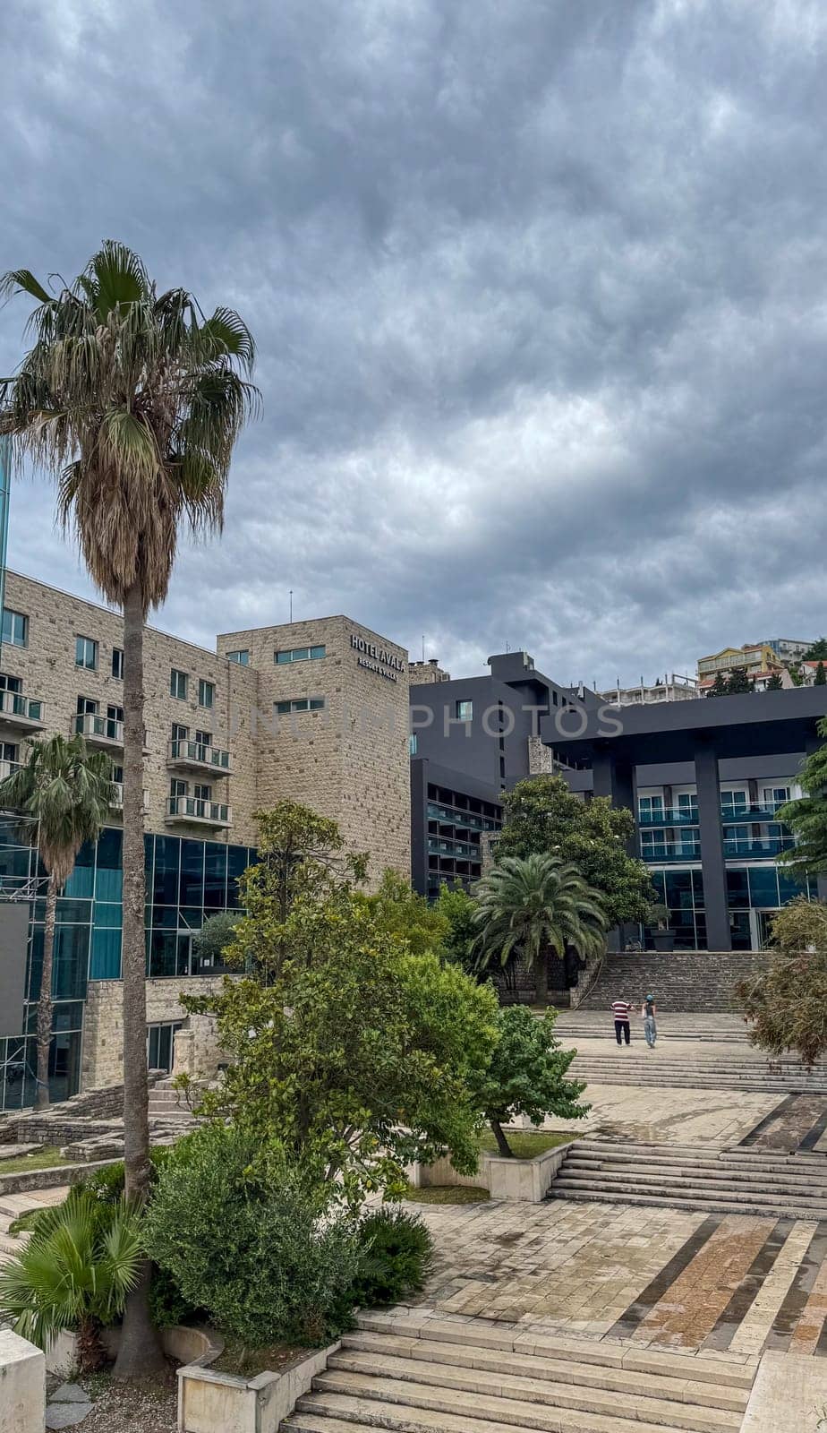 Budva, Montenegro - May 21, 2025: AVALA Hotel showcases modern architecture surrounded by palm trees and greenery