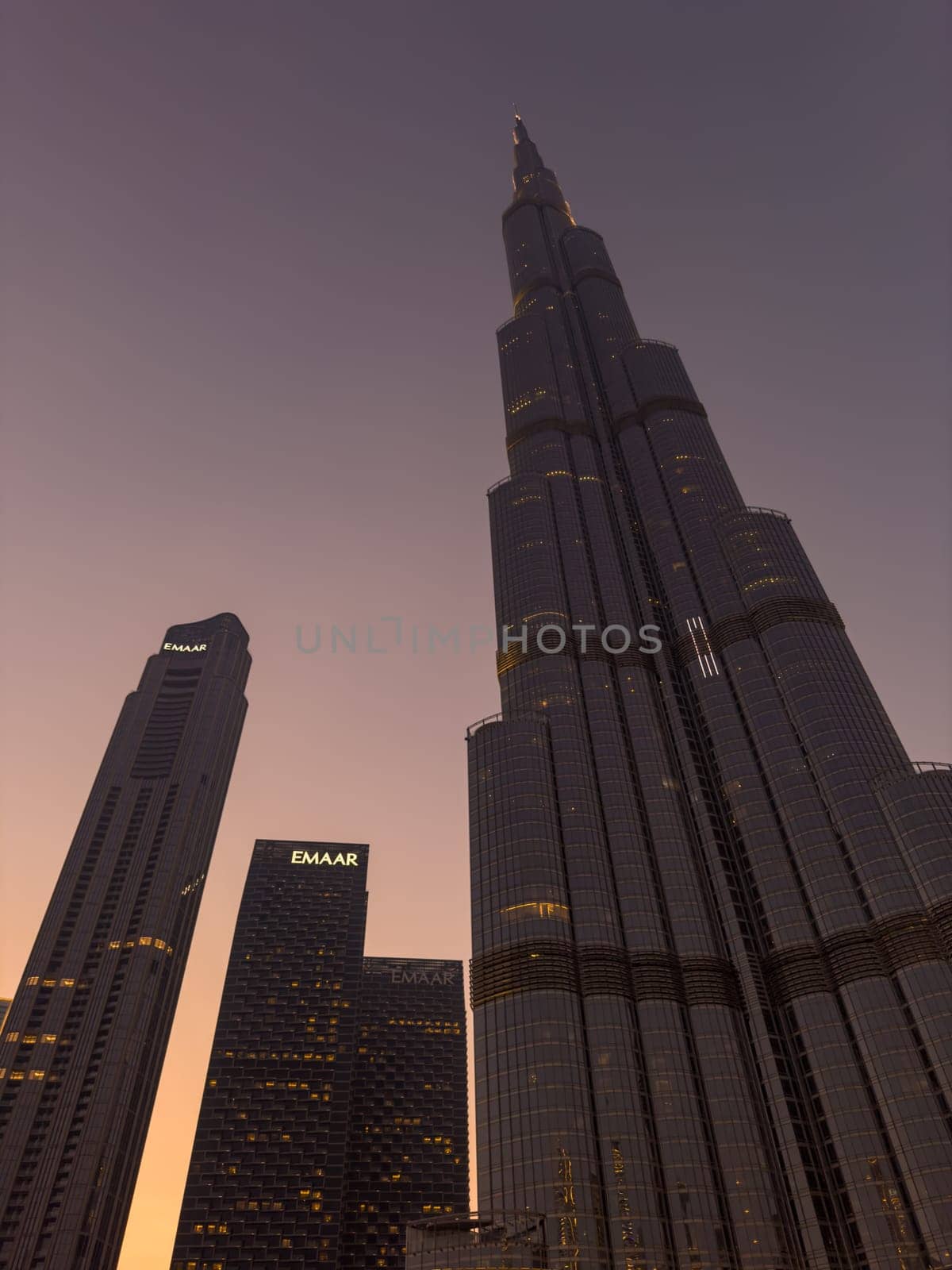 UAE, Dubai, 26 September 2024: The famous shopping center Dubai Mall and Burj Khalifa skyscraper at dusk, Dubai's sights and skyscrapers illuminated at night, palm trees. High quality photo