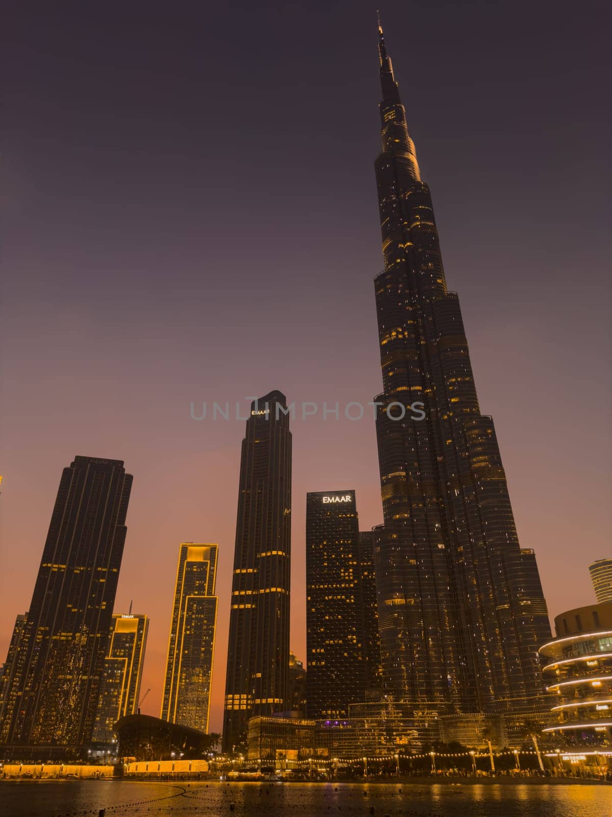UAE, Dubai, 26 September 2024: The famous shopping center Dubai Mall and Burj Khalifa skyscraper at dusk, Dubai's sights and skyscrapers illuminated at night, palm trees. High quality photo