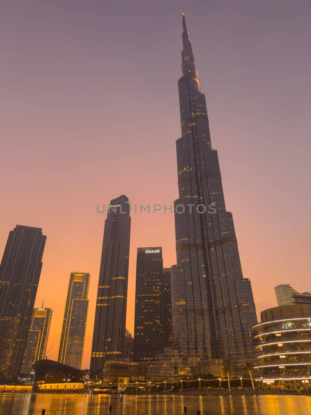 UAE, Dubai, 26 September 2024: The famous shopping center Dubai Mall and Burj Khalifa skyscraper at dusk, Dubai's sights and skyscrapers illuminated at night, palm trees. High quality photo