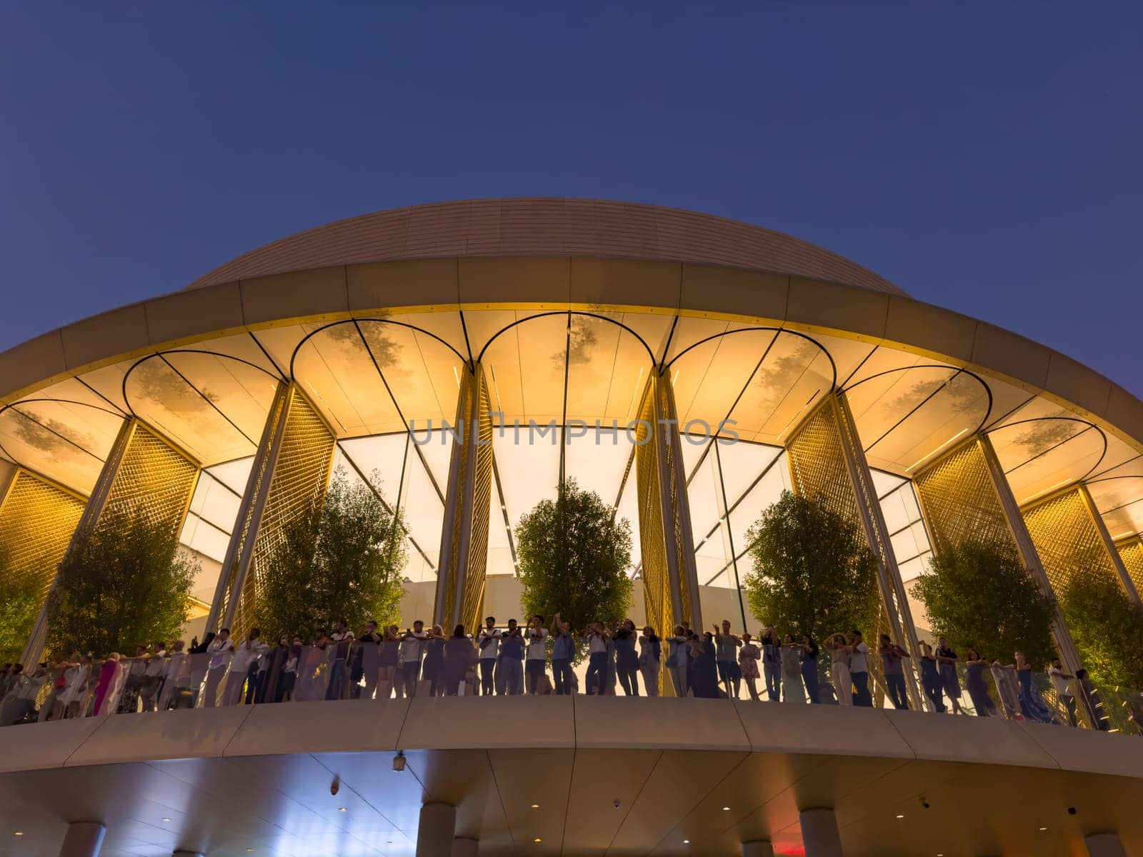 UAE, Dubai, 26 September 2024: people on the balcony of the central Apple store in Dubai Mall, The famous shopping center Dubai Mall and Burj Khalifa skyscraper at dusk. High quality photo