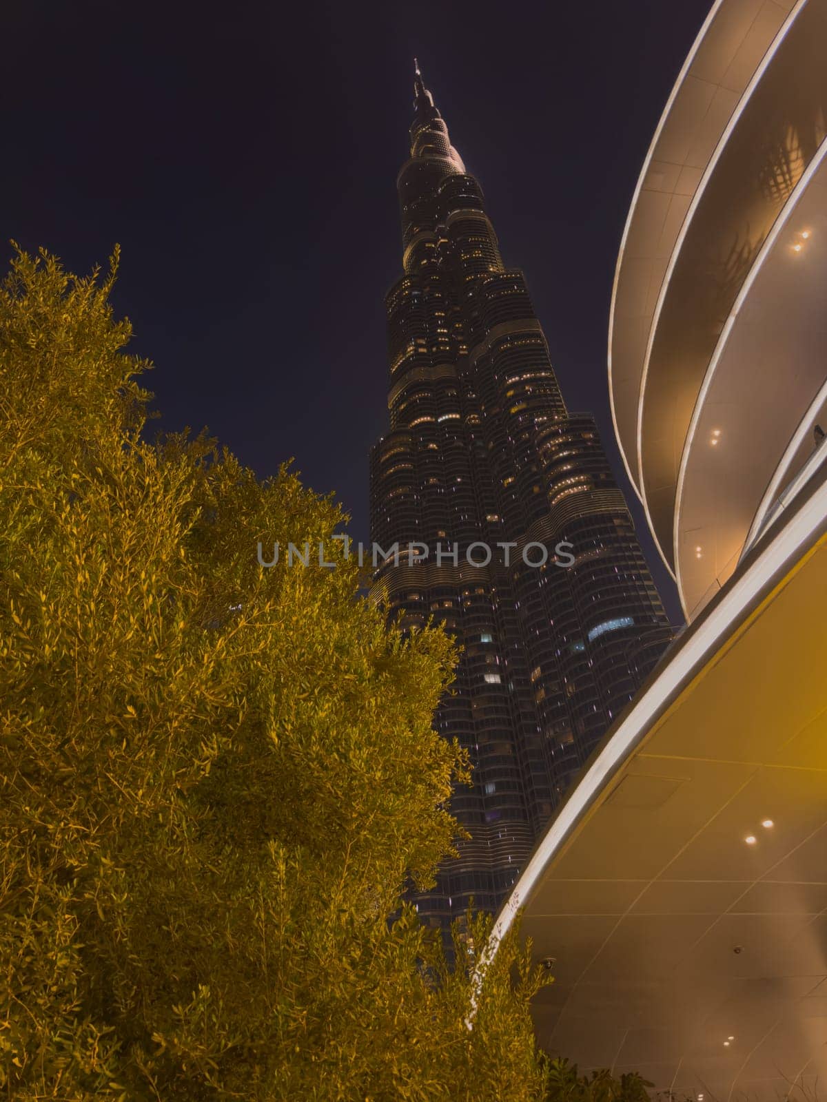 UAE, Dubai, 26 September 2024: The famous shopping center Dubai Mall and Burj Khalifa skyscraper at dusk, Dubai's sights and skyscrapers illuminated at night, palm trees. High quality photo