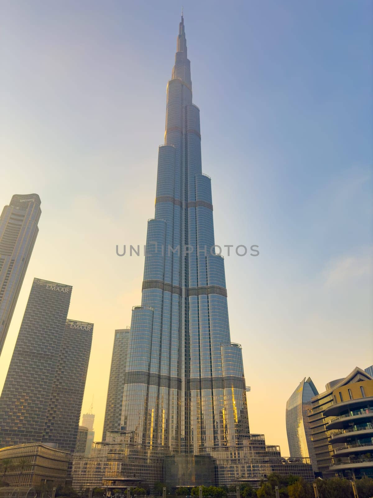 UAE, Dubai, 26 September 2024: The famous shopping center Dubai Mall and Burj Khalifa skyscraper at dusk, Dubai's sights and skyscrapers illuminated at night, palm trees. High quality photo
