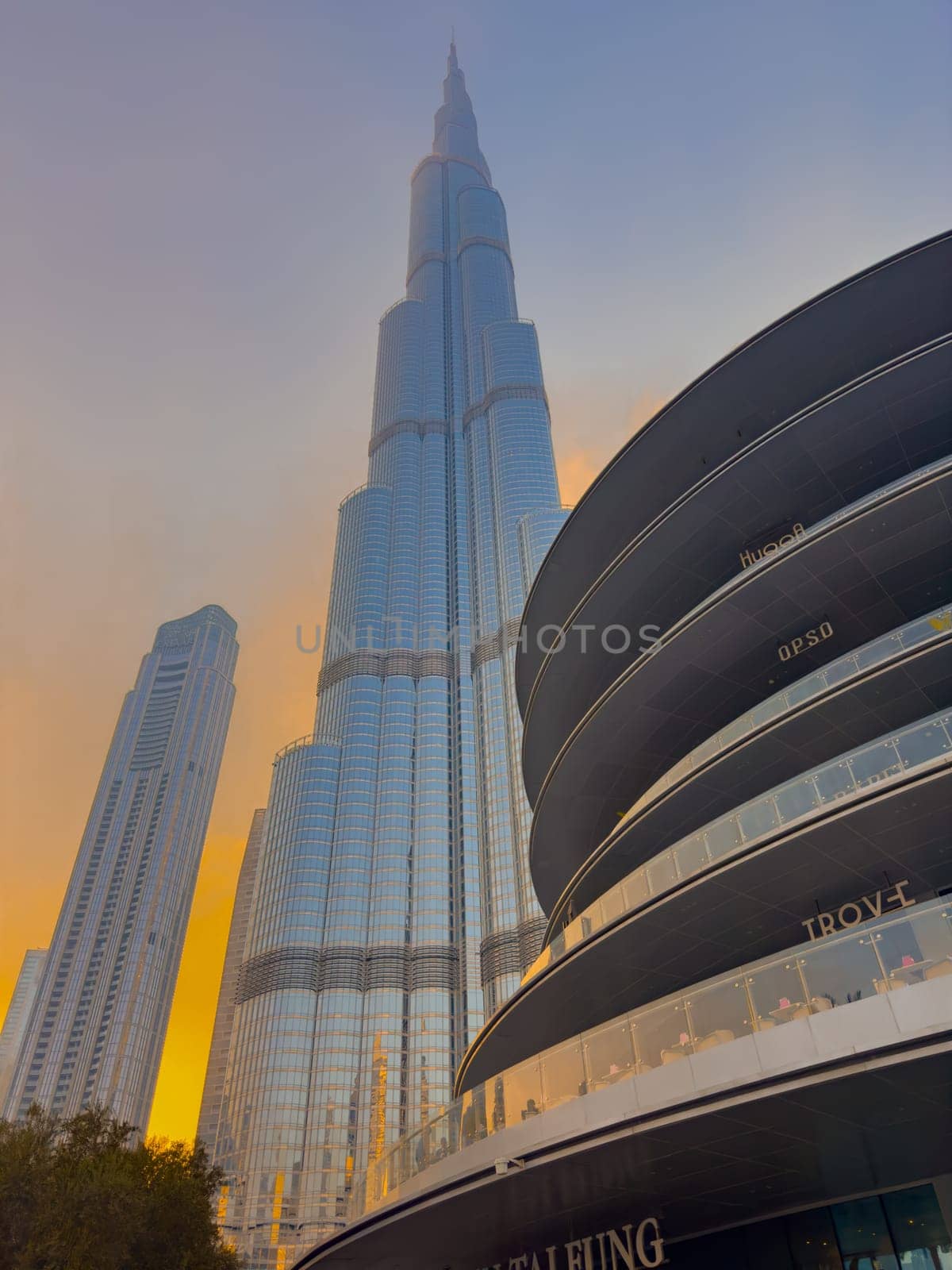 UAE, Dubai, 26 September 2024: The famous shopping center Dubai Mall and Burj Khalifa skyscraper at dusk, Dubai's sights and skyscrapers illuminated at night, palm trees. High quality photo