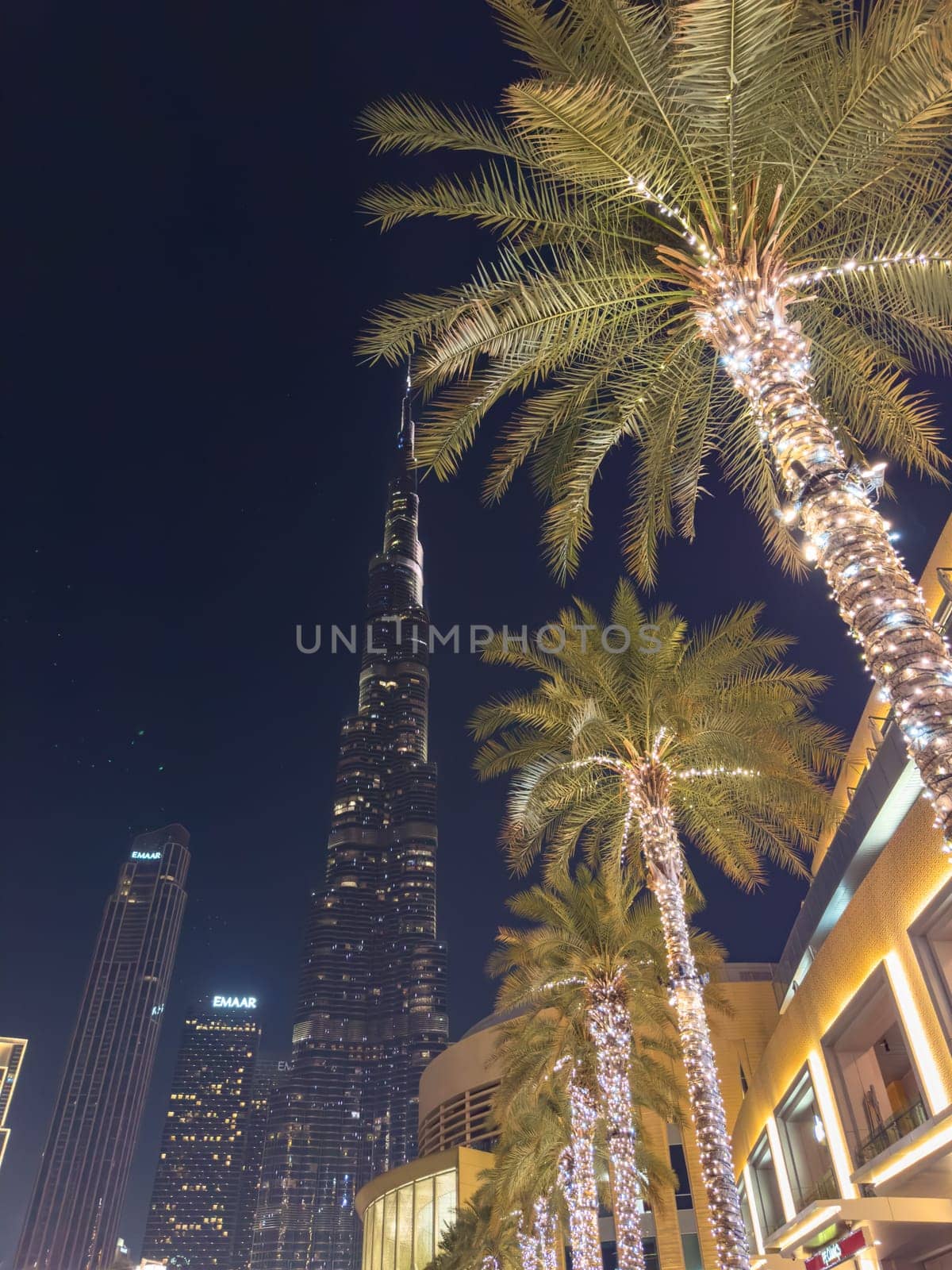 UAE, Dubai, 26 September 2024: The famous shopping center Dubai Mall and Burj Khalifa skyscraper at dusk, Dubai's sights and skyscrapers illuminated at night, palm trees. High quality photo