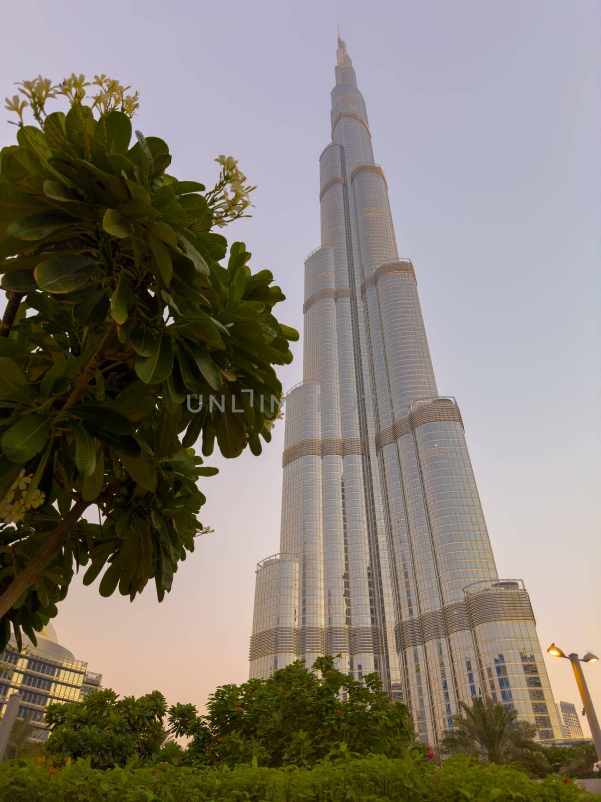 UAE, Dubai, 26 September 2024: The famous shopping center Dubai Mall and Burj Khalifa skyscraper at dusk, Dubai's sights and skyscrapers illuminated at night, palm trees. High quality photo
