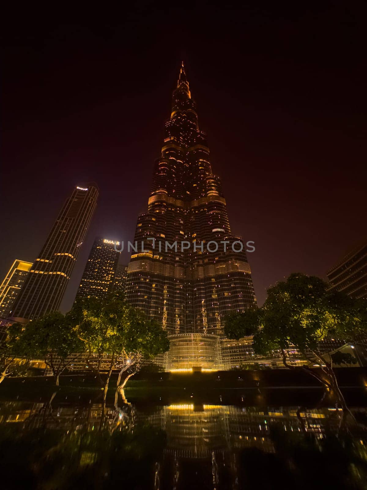 UAE, Dubai, 26 September 2024: The famous shopping center Dubai Mall and Burj Khalifa skyscraper at dusk, Dubai's sights and skyscrapers illuminated at night, palm trees. High quality photo