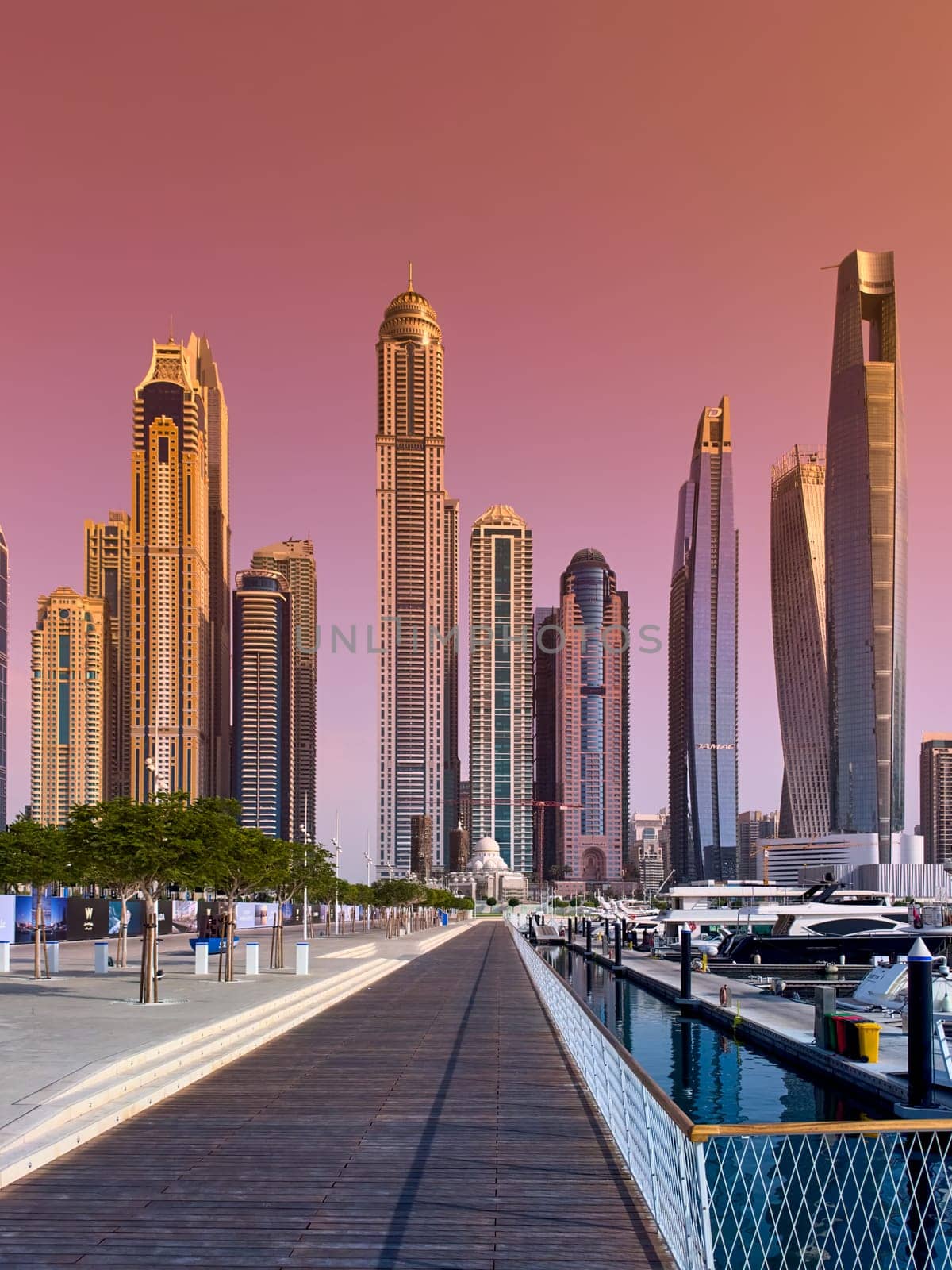 UAE, Dubai, 29 September 2024: Skyscrapers from Dubai harbor marina at sunny day, luxury yachts and boats are moored in port. High quality photo