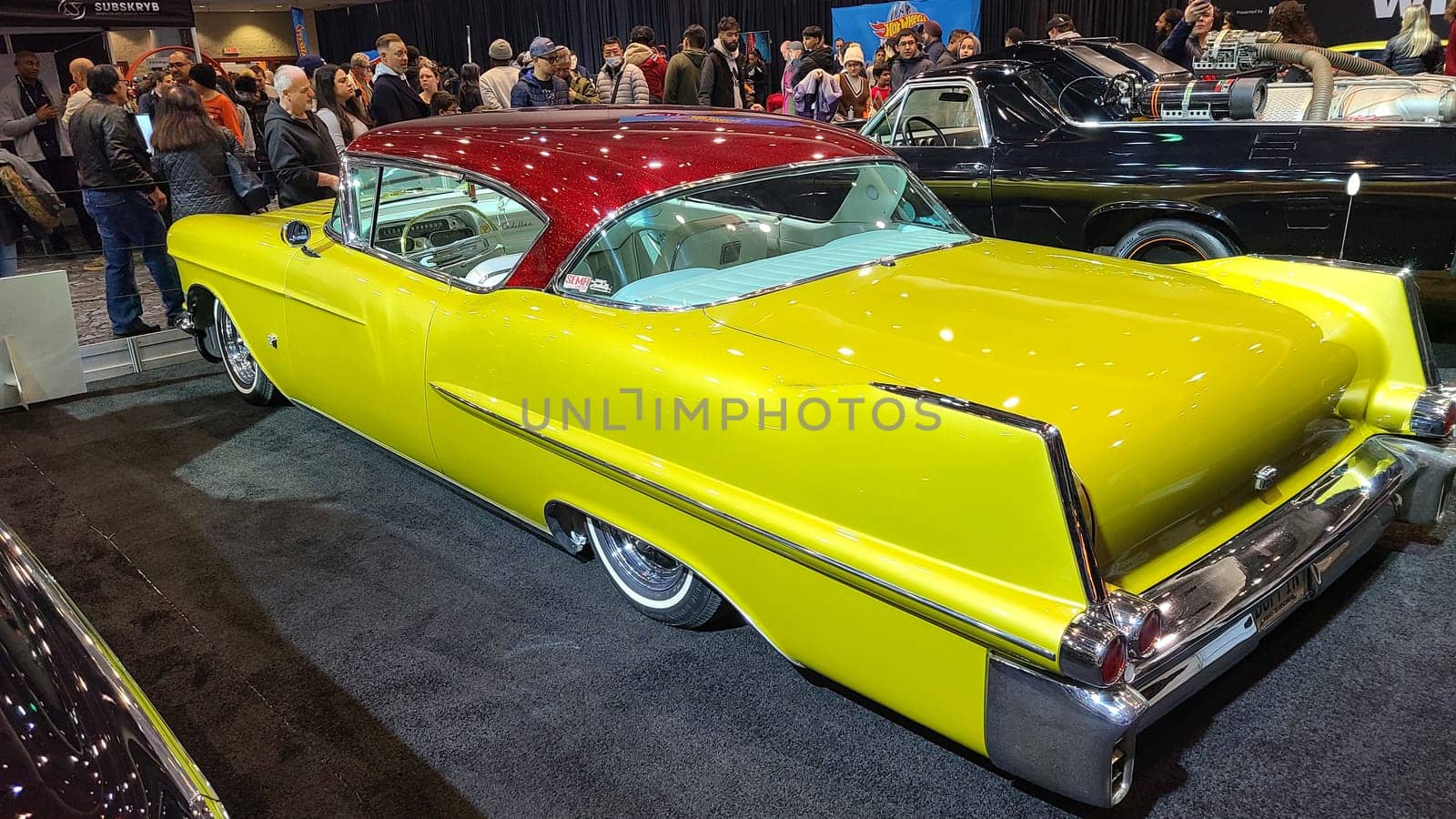 Toronto, ON Canada - 02.19.2023: Classic Cadillac Car Show Striking Yellow Vintage Automobile with Red Roof Displayed for Auto Enthusiasts.