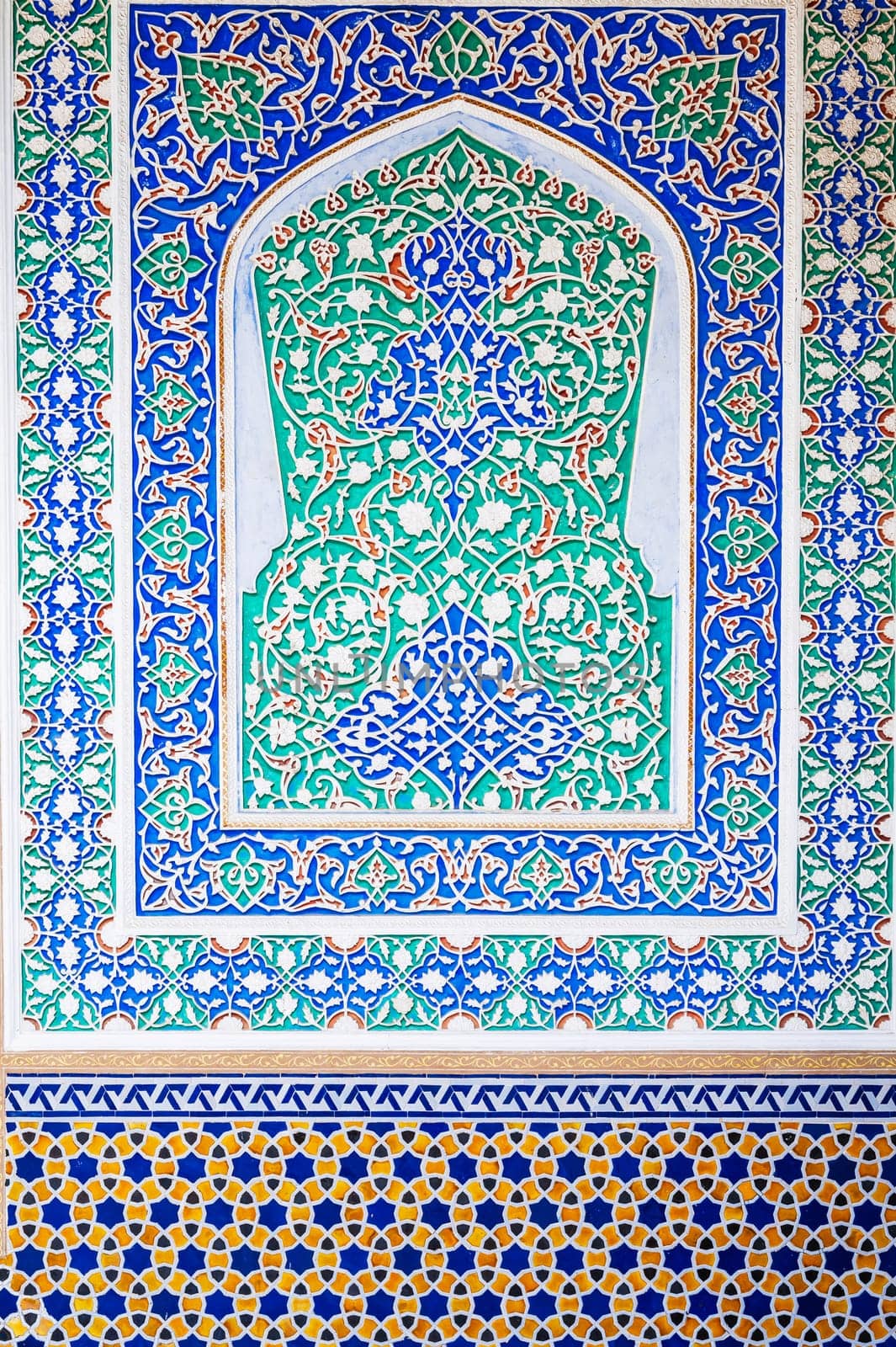 background of painted carved wooden wall with traditional Uzbek ornaments and colorful oriental patterns in Tashkent in Uzbekistan